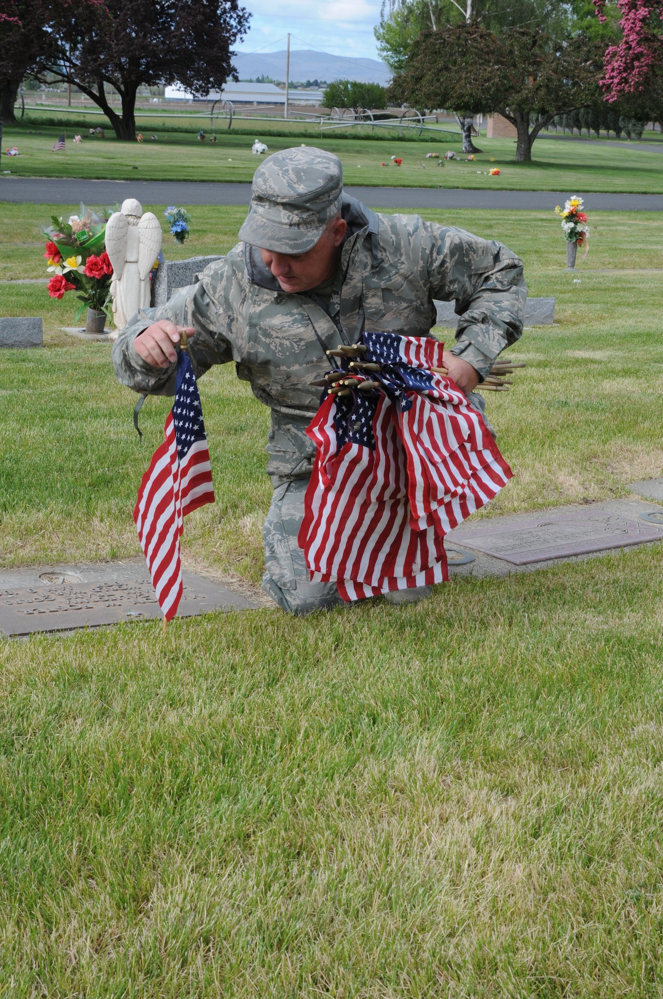 U.S. Air National Guard Master Sgt. Dave Smith, 173rd Fighter Wing, places a flag on the graves of local veterans at Mount Calvary Cemetery in Klamath Falls, Ore. May 23, 2013.  Members of the 173rd Fighter Wing spent their morning placing flags in honor of Memorial Day.  (U.S. Air National Guard photo by Master Sgt. Jennifer Shirar) RELEASED  