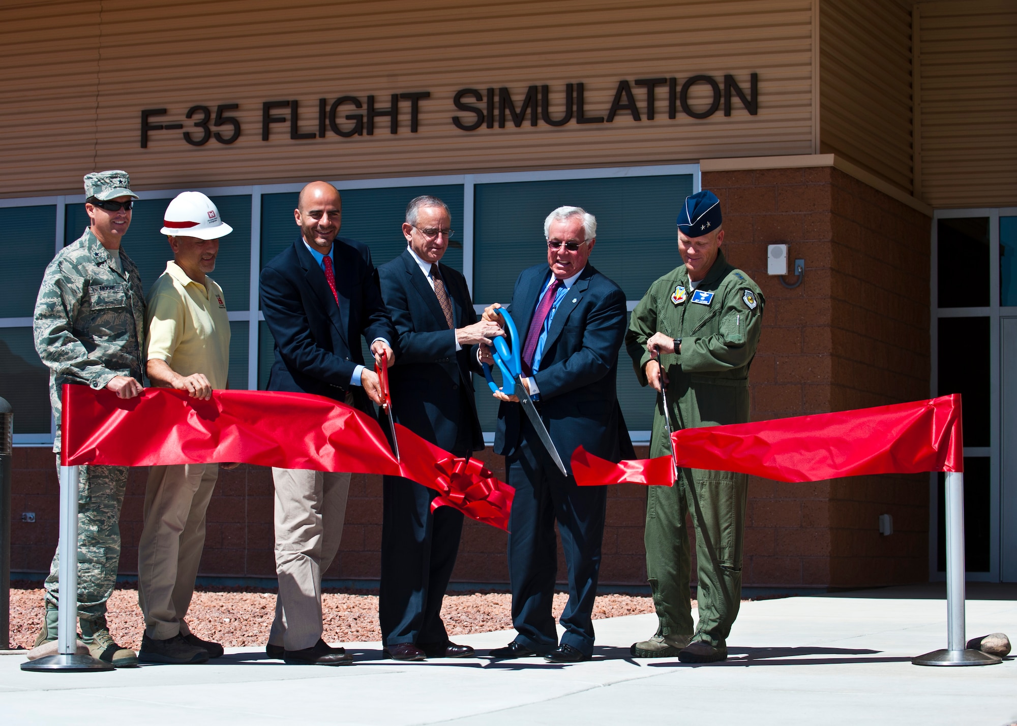 (From left to right)Brig. Gen. Charles Moore, 57th Wing commander; Pete Pupparo, U.S. Army Corps of Engineers resident engineer; Ray Haj, Swinerton Builders Government Division vice president; Michael Zettler, F-35 Sustainment at Lockheed Martin vice president; Randy Black, United States Air Force Warfare Center honorary commander; and Maj. Gen. Jeffrey Lofgren, USAFWC commander, cut the ribbon at the new F-35 simulator facility during a ribbon cutting ceremony May 23, 2013, at Nellis Air Force Base, Nev. The F-35 simulator facility was built to provide realistic training that is independent of the weather, maintenance, and range availability that can challenge daily operations. (U.S. Air Force photo/Senior Airman Brett Clashman)