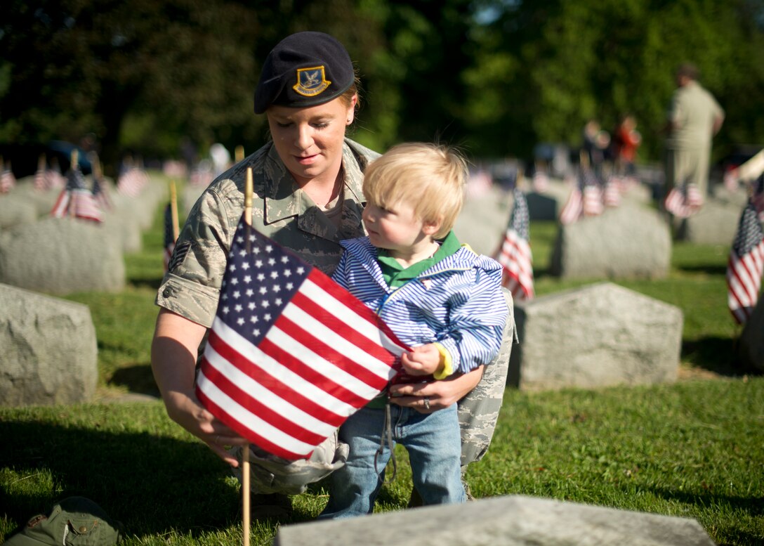 914th Airlift Wing Security Forces Staff Sgt. Tara Wichtowski and her son place an American flag on a veteran’s grave during a Memorial Day ceremony held at Forest Lawn Cemetery on May 27, 2013, Buffalo NY. During the morning ceremony volunteers placed thousands of flags next to the graves of the men and woman who served in the United States military. (U.S. Air Force photo by Tech. Sgt. Joseph McKee)