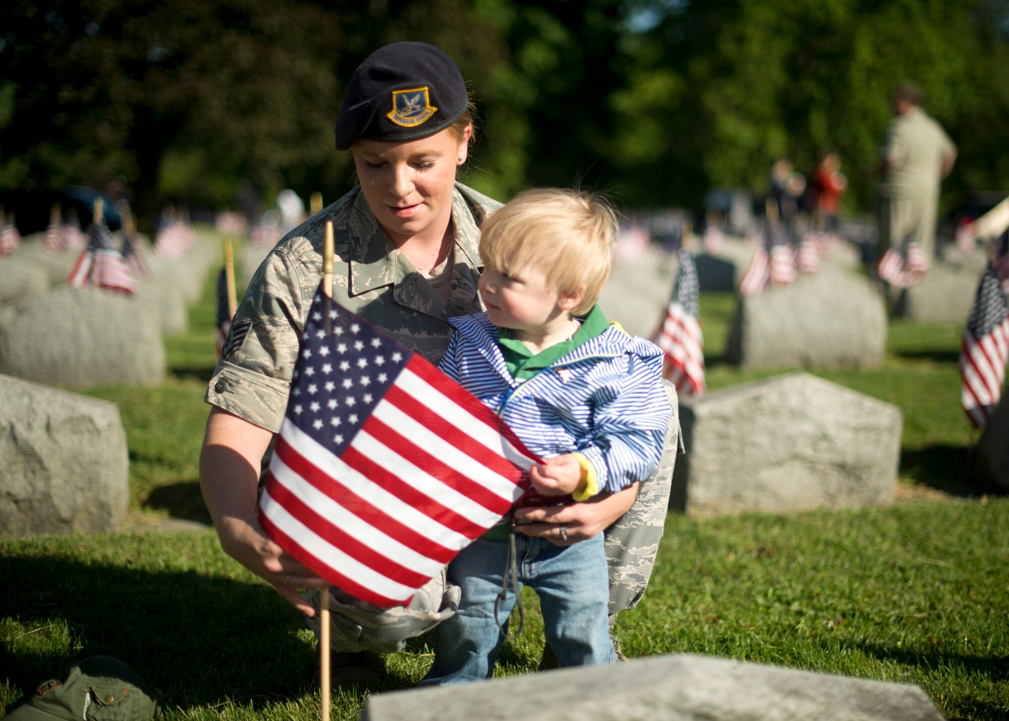 914th Airlift Wing Security Forces Staff Sgt. Tara Wichtowski and her son place an American flag on a veteran’s grave during a Memorial Day ceremony held at Forest Lawn Cemetery on May 27, 2013, Buffalo NY. During the morning ceremony volunteers placed thousands of flags next to the graves of the men and woman who served in the United States military. (U.S. Air Force photo by Tech. Sgt. Joseph McKee)