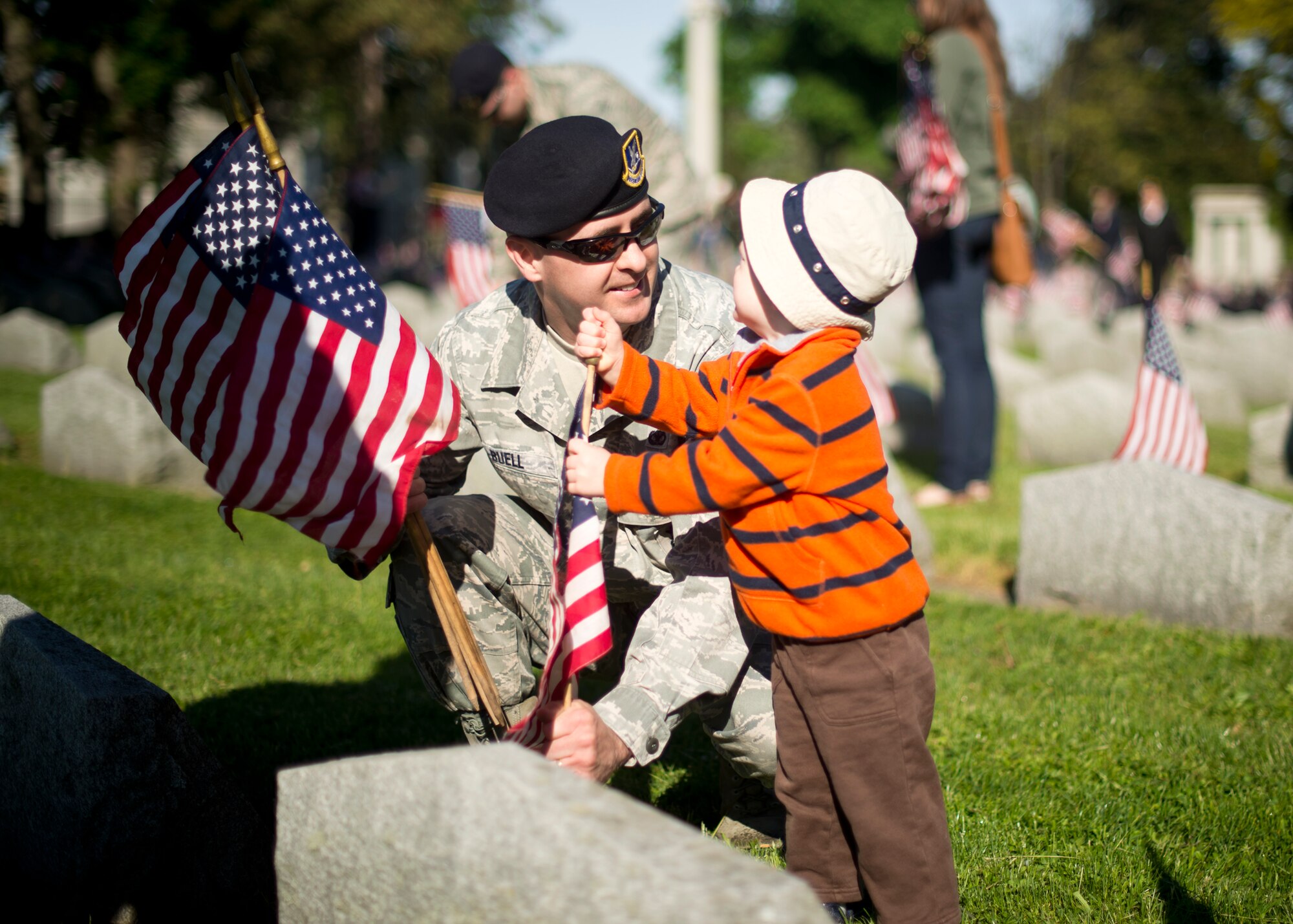914th Airlift Wing Security Forces Master Sgt. David Buel and his son place an American flag on a veteran’s grave during a Memorial Day ceremony held at Forest Lawn Cemetery on May 27, 2013, Buffalo NY. During the morning ceremony volunteers placed thousands of flags next to the graves of the men and woman who served in the United States military. (U.S. Air Force photo by Tech. Sgt. Joseph McKee)