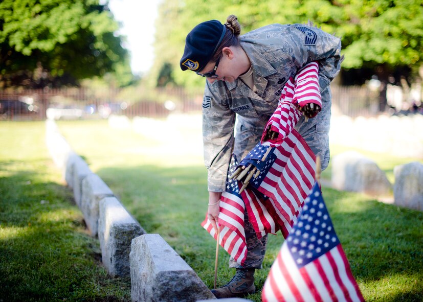 914th Airlift Wing Security Forces Tech. Sgt. Lynn Magistrale places an American flag on veteran’s grave during a Memorial Day ceremony, May 27, 2013, Forest Lawn Cemetery Buffalo NY. During the morning ceremony volunteers placed thousands of flags next to the graves of the men and woman who served in the United States military. (U.S. Air Force photo by Tech. Sgt. Joseph McKee)