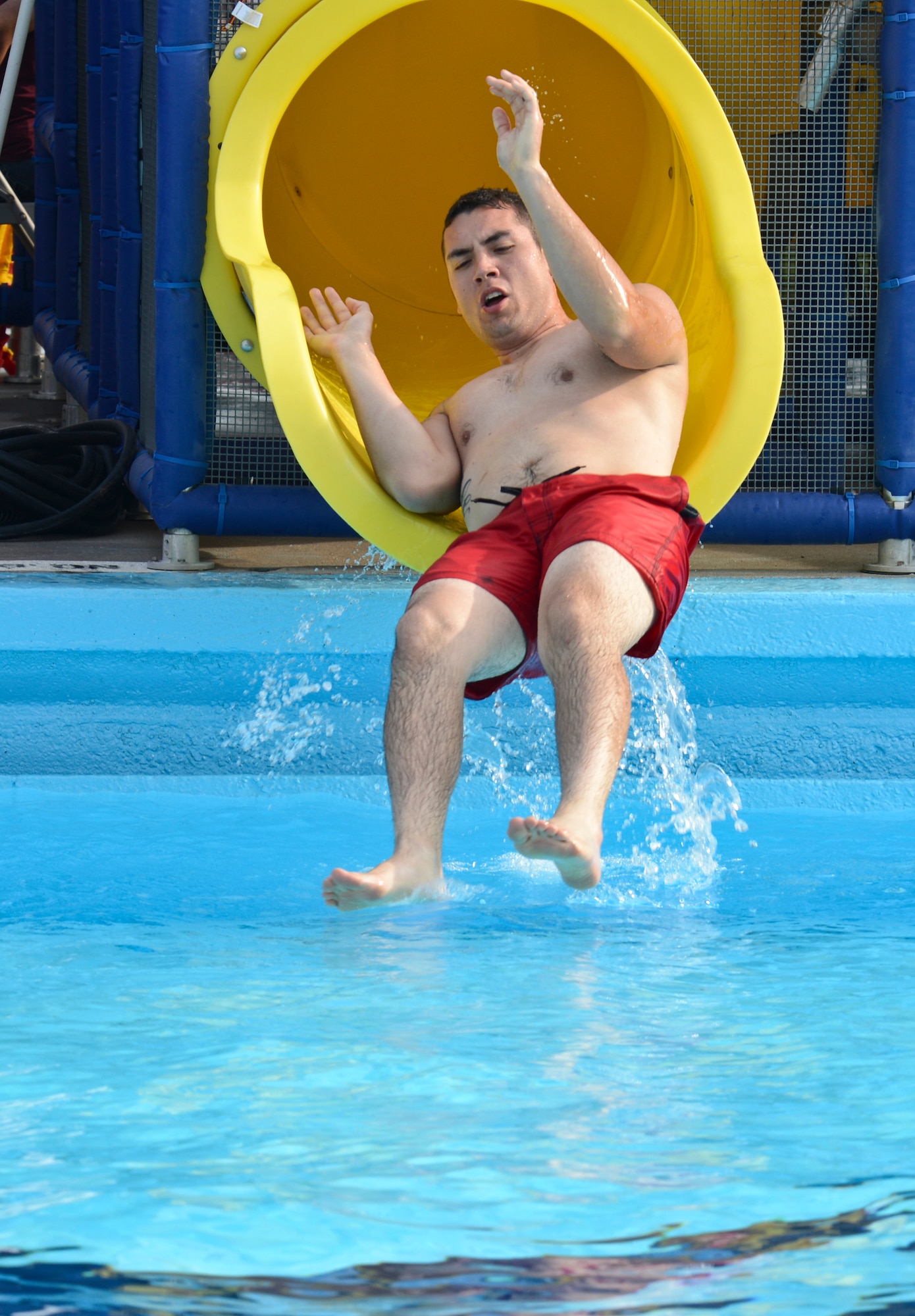 Senior Airman Steven Price, 2nd Civil Engineer Squadron, slides down a waterslide during the Pool Bash at the North Gate Pool on Barksdale Air Force Base, La., May 24, 2013. The pool area received several new additions such as a concession stand, renovated bathrooms, four large waterslides and a salt water chlorination machine. (U.S. Air Force photo/Senior Airman Micaiah Anthony)