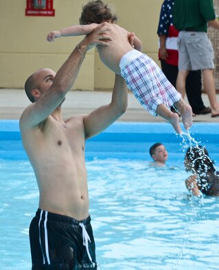1st Lt. Cameron Bowsky, 2nd Civil Engineer Squadron, plays with his son during the Pool Bash on Barksdale Air Force Base, La., May 24, 2013. The Pool Bash was held for the grand re-opening of the pool after several renovations were made. (U.S. Air Force photo/Senior Airman Micaiah Anthony)