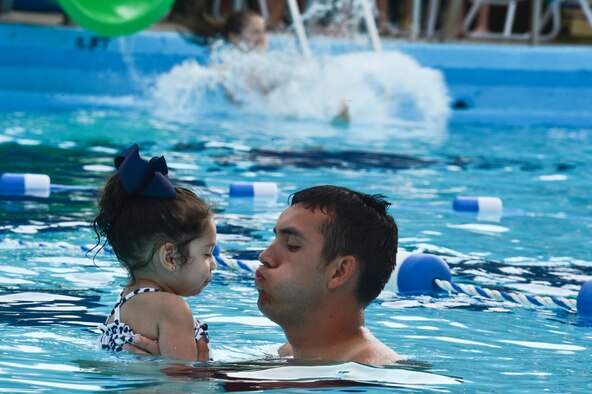Senior Airman Steven Price, 2nd Civil Engineer Squadron, plays with his daughter during the Pool Bash on Barksdale Air Force Base, La., May 24, 2013. During the event, refreshments, music and free pool toys were provided for participants to enjoy. (U.S. Air Force photo/Senior Airman Micaiah Anthony)