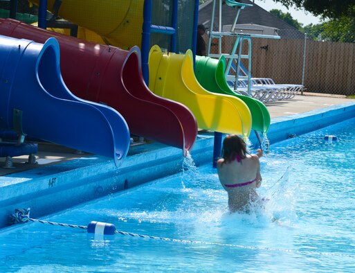 A Pool Bash guest becomes the first person to slide down the new waterslide at the North Gate Pool on Barksdale Air Force Base, La., May 24, 2013. Four people were selected to be the first to slide down each waterslide to christen the new addition of the pool area. (U.S. Air Force photo/Senior Airman Micaiah Anthony)