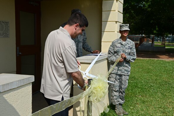 Col. Andrew Gebara, 2nd Bomb Wing commander, cuts a ribbon in front of the North Gate Pool on Barksdale Air Force Base, La., May 24, 2013. The ribbon cutting ceremony was held for the re-opening of the pool after several renovations were made. (U.S. Air Force photo/Senior Airman Micaiah Anthony)