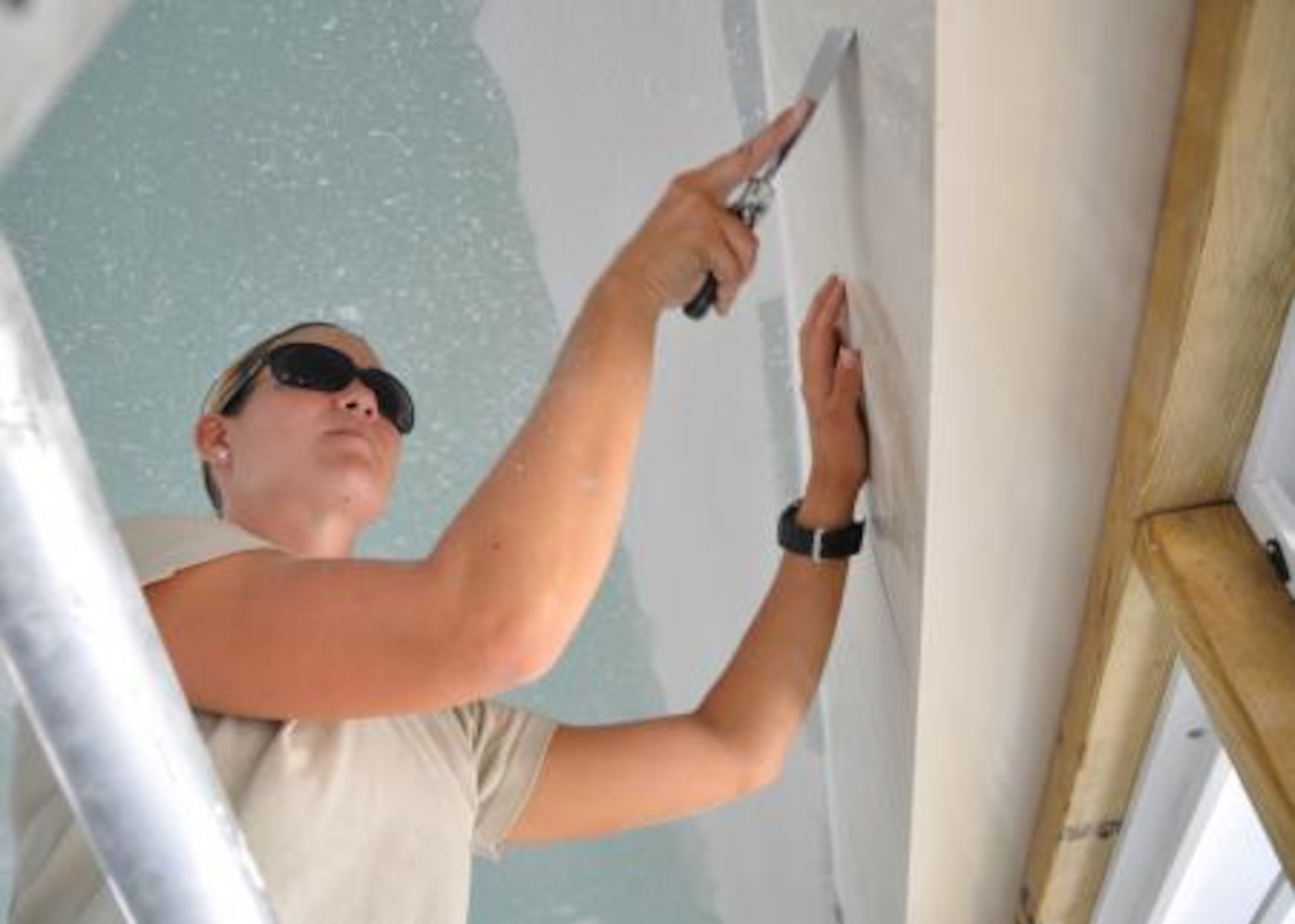 Senior Airman Stephanie Cannon, medical technician from the 92nd Medical Operations Squadron removes excess texture coating from the walls of Crooked Tree Government Primary School May 24, 2013. Civil Engineers from both the U.S. and Belize are constructing various structures at schools throughout Belize as part of an exercise called New Horizons. Building these facilities will support further education for the children of the country and provide valuable training for U.S. and Belizean service members. (U.S. Air Force photo/Capt. Holly Hess)
