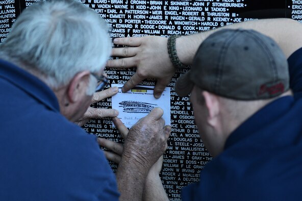 Larry Nichols (left), retired Air Force master sergeant, and Caleb Sowders,  a volunteer, procure a name from The Vietnam Traveling Memorial Wall by means of  lead rubbing, Sumter, S.C., May 24, 2013. The traveling memorial wall is a three-fifths scale replica of the Vietnam Memorial in Washington, D.C. The wall stands as a reminder of the great sacrifices made during the Vietnam War. (U.S. Air Force photo by Airman 1st Class Daniel Blackwell/Released)