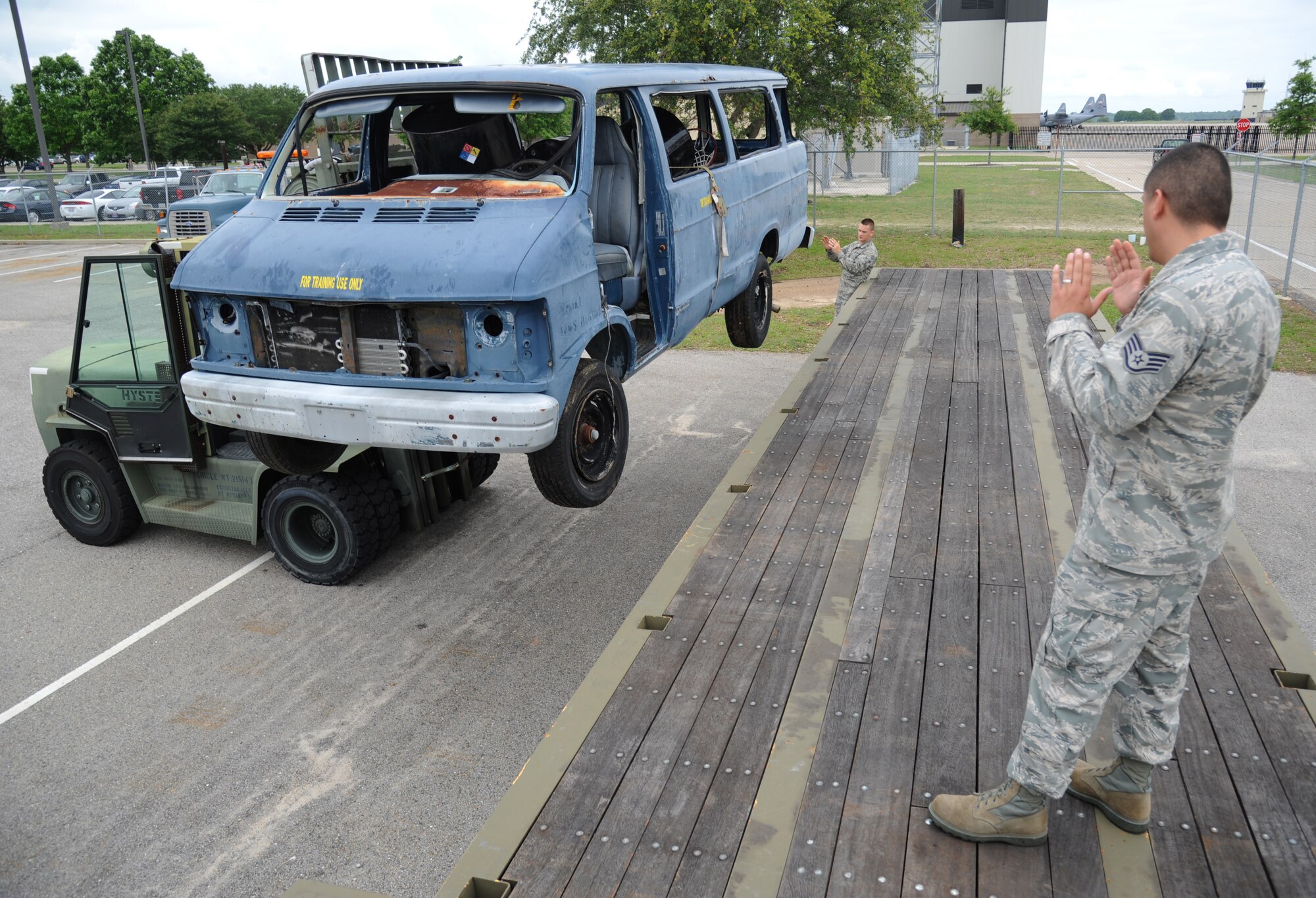 Airman 1st Class James Heninger and Staff Sgt. Michael Cuellar, 81st Logistics Readiness Squadron, guides  a training van onto the bed of a flatbed truck May 23, 2013, at vehicle operations, Keesler Air Force Base, Miss.  One of the flight’s duties is transporting vehicles wherever necessary.  (U.S. Air Force photo by Kemberly Groue)