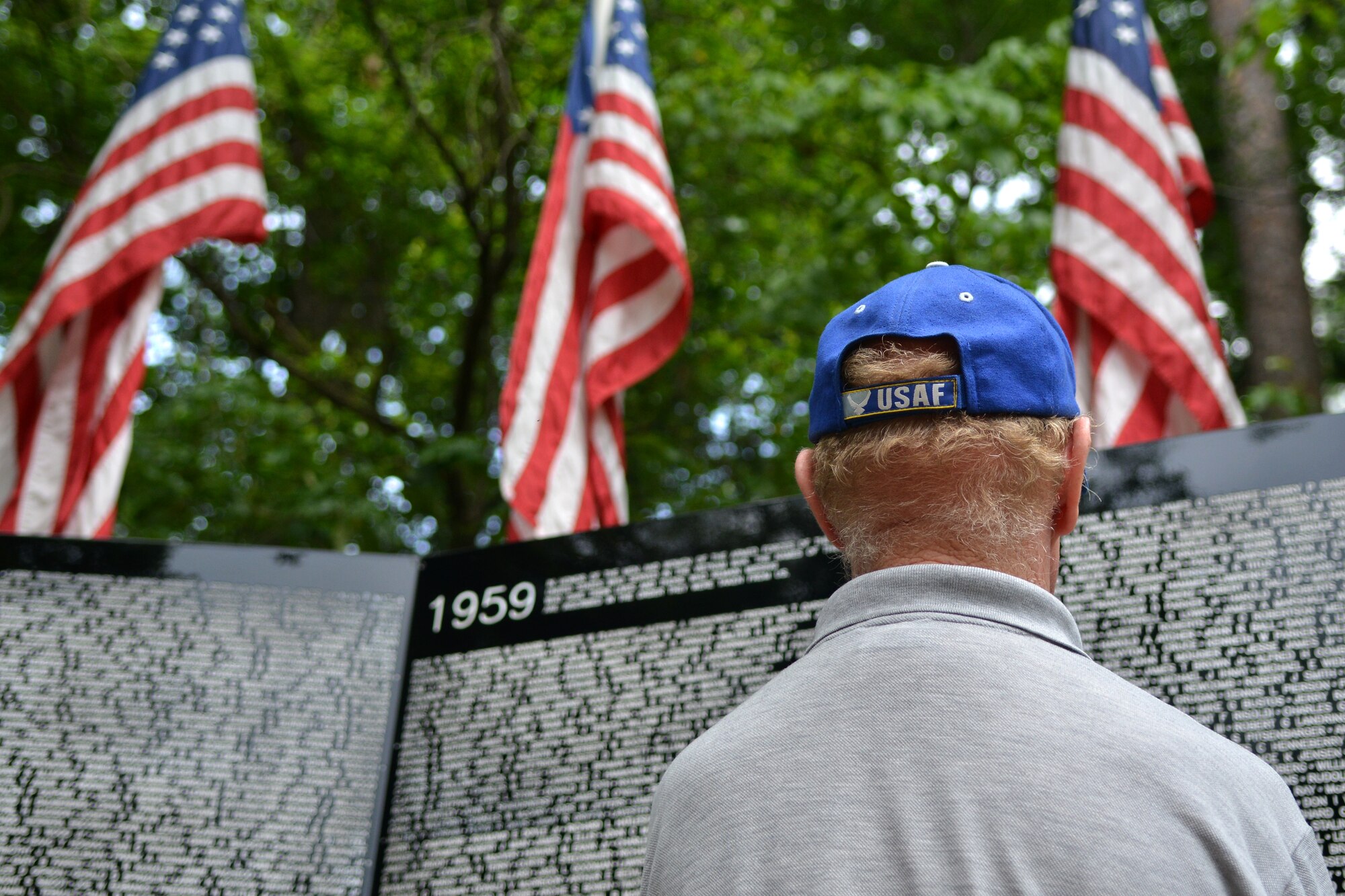 Retired U.S. Air Force Master Sgt. Ron Adams stares at the Vietnam Wall Memorial looking up the names of his friends who passed away during the Vietnam War, Sumter, S.C., May 23, 2013. The traveling memorial made its only stop in S.C. at Sumter’s Swan Lake. The wall stands six feet tall at the center and covers almost 300 feet from end to end. (U.S. Air Force photo by Airman 1st Class Ashley L. Gardner/ Released)