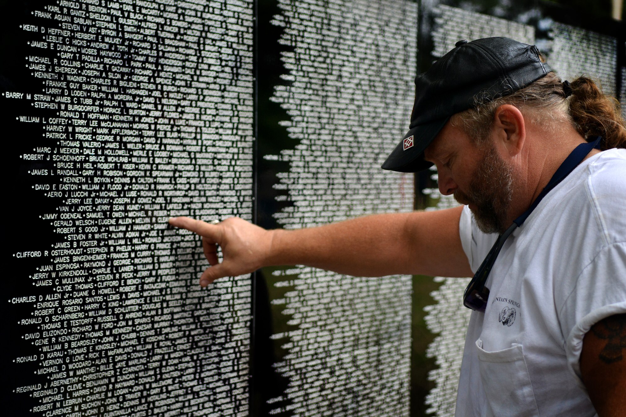 Jim Gates takes a moment of remembrance for a friend whose name is on the Traveling Vietnam Memorial Wall, Sumter, S.C., May 23, 2013. The traveling memorial made its only stop in S.C., at Sumter’s Swan Lake. The wall stands six feet tall at the center and covers almost 300 feet from end to end. (U.S. Air Force photo by Airman 1st Class Ashley L. Gardner/ Released)