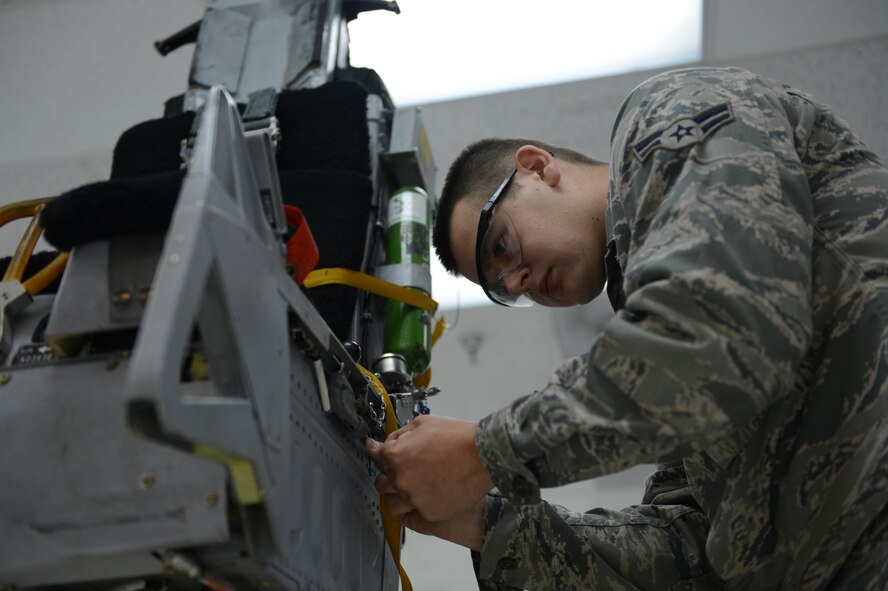 Airman 1st Class Nate Shepler, 20th Component Maintenance Squadron aircrew egress system technician, replaces the safety wire on a cable connected to the harness handle of an F-16 Fighting Falcon seat to prevent malfunctions, May 14, 2013, Shaw Air Force Base, S.C. The ejection seat is part of the egress system along with the cockpit’s canopy. The system allows pilots to eject safely from the aircraft. (U.S. Air Force photo by Airman 1st Class Krystal M. Jeffers/Released)