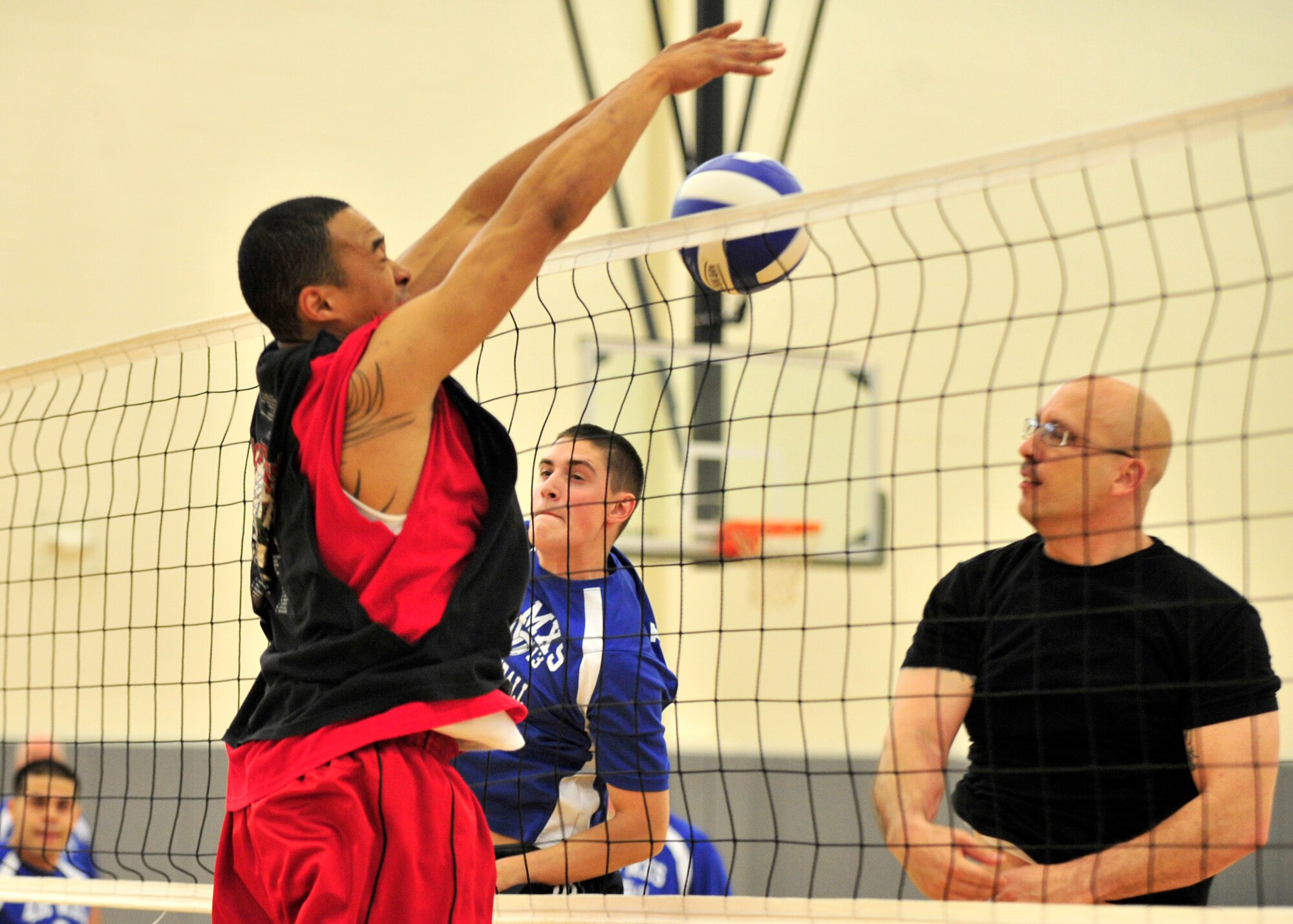 James Jones, 736th Aircraft Maintenance Squadron player-coach, slams home a block as Patrick Piazza, 436th Maintenance Squadron looks on during the intramural volleyball championship May 21, 2013, at the fitness center on Dover Air Force Base, Del. The 736th AMXS defeated the 436th MXS 25-19, 14-25, and 17-15 to win the title for the third year in a row. (U.S. Air Force photo/Tech. Sgt. Chuck Walker)