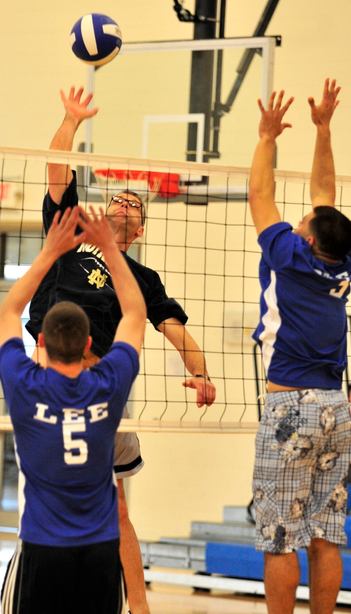 Tim Hellman, 736th Aircraft Maintenance Squadron, goes up for a kill as the 436th Maintenance Squadron attempts to block during the intramural volleyball championship game May 21, 2013, at the fitness center on Dover Air Force Base, Del. The 736th AMXS won the championship 25-19, 14-25, and 17-15. (U.S. Air Force photo/Tech. Sgt. Chuck Walker)