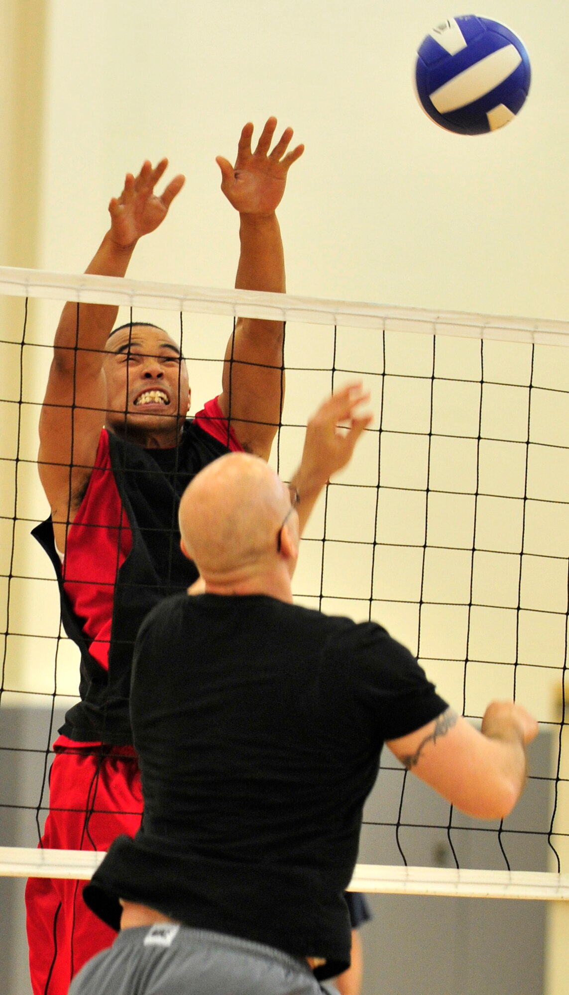 James Jones, 736th Aircraft Maintenance Squadron player-coach, goes up for a block against the 436th Maintenance Squadron during the intramural volleyball championship game May 21, 2013, at the fitness center on Dover Air Force Base, Del. The 736th AMXS won the championship for the third year in a row defeating the 436th MXS 25-19, 14-25, 17-15. (U.S. Air Force photo/Tech. Sgt. Chuck Walker)