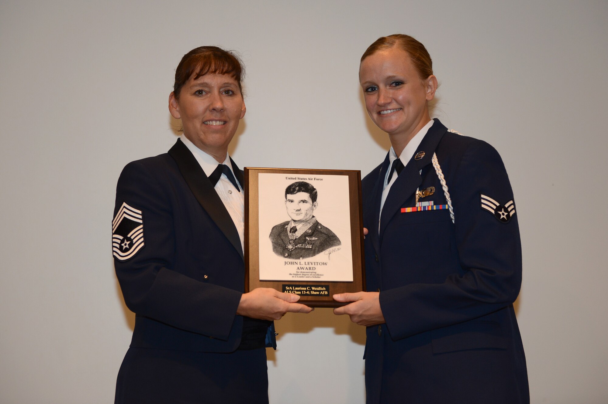 Senior Airman Laurissa Weidlich, 31st Intelligence Squadron crypto logic language analysis, is presented with the John L. Levitow award at Shaw Air Force Base, S.C., May 16, 2013. The award is presented to the student in the class who achieves the highest overall points in academic achievement, leadership and teamwork. It is the highest award in enlisted Professional Military Education. (U.S. Air Force photo by Airman 1st Class Krystal M. Jeffers/Released)