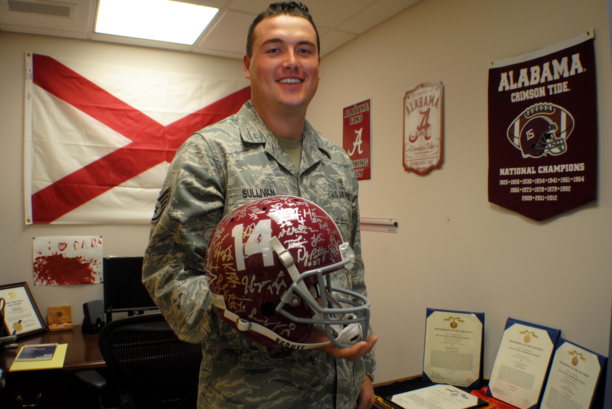Staff Sgt. Thomas C. Sullivan Jr., 319th Medical Support Squadron laboratory technician, holds up a University of Alabama Crimson Tide football helmet signed by the entire team that won the school’s fifteenth Division 1 National Championship, May 22, 2013, at his office on Grand Forks Air Force Base, N.D. The 27-year-old native from Dothan, Ala., is Grand Forks AFB’s Warrior of the Week for the last week of May 2013. (U.S. Air Force photo/Staff Sgt. Luis Loza Gutierrez)
