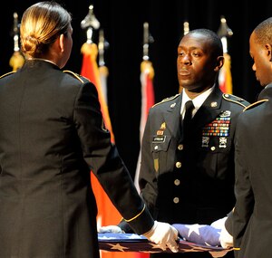 Soldiers from the 7th Sustainment Brigade perform a flag folding ceremony during the Memorial Day Ceremony at Jacobs Theater at Fort Eustis, Va., May 23, 2013. The ceremony included a guest speaker, a performance by the U.S. Army Training and Doctrine Command Band and a 21-gun salute in honor of fallen U.S. Service members. (U.S. Air Force photo by Staff Sgt. Dana Hill/Released)