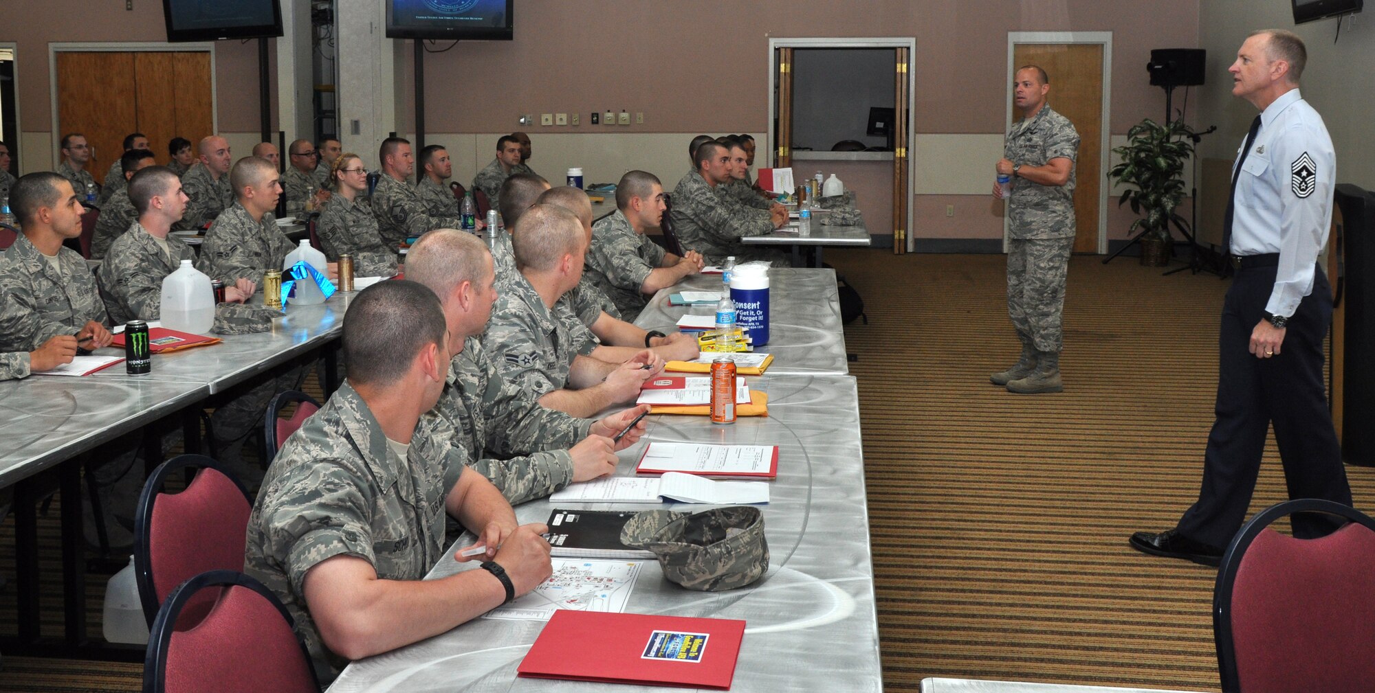 GOODFELLOW AIR FORCE BASE, Texas- Col. Mark Damiano, former 17th Training Wing Commander, and Chief Master Sgt. Scott Lumpkin, 17th Training Wing Command Chief Master Sergeant, brief in-processing students on base expectations and standards at the event center, April 30. The briefing is part of the new in-processing method implemented at Goodfellow. (U.S. Air Force photo/ Airman 1st Class Joshua Edwards)