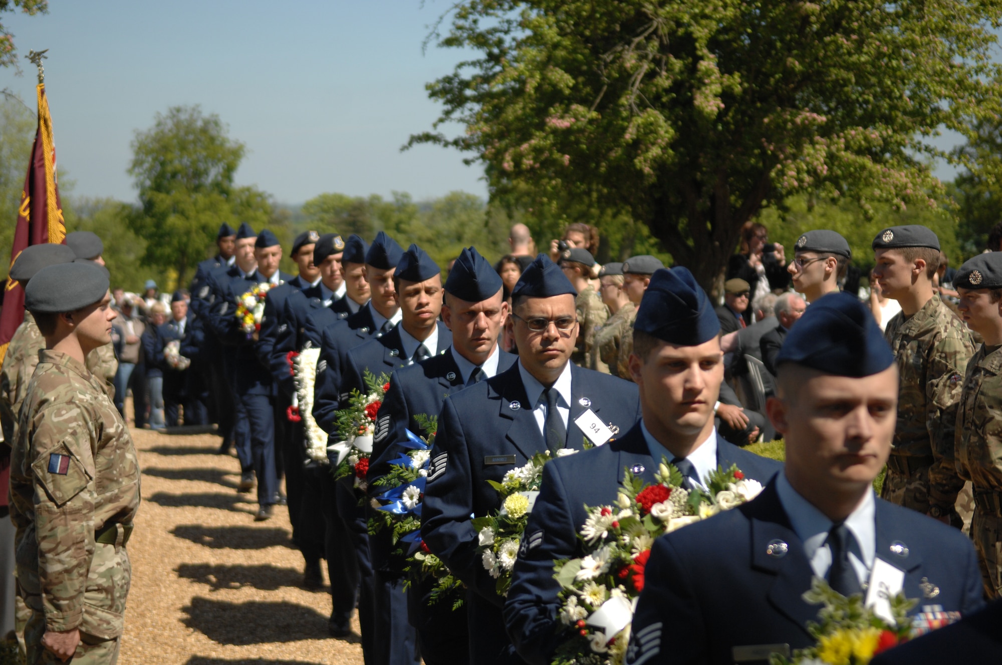 Airmen march past a column of British service members while holding wreaths during the Memorial Day ceremony May 27, 2013, at the Madingley American Cemetery in Cambridge, England. Airmen from RAF Mildenhall and RAF Lakenheath, England, participated in the ceremony. (U.S. Air Force photo by Airman 1st Class Dillon Johnston/Released)