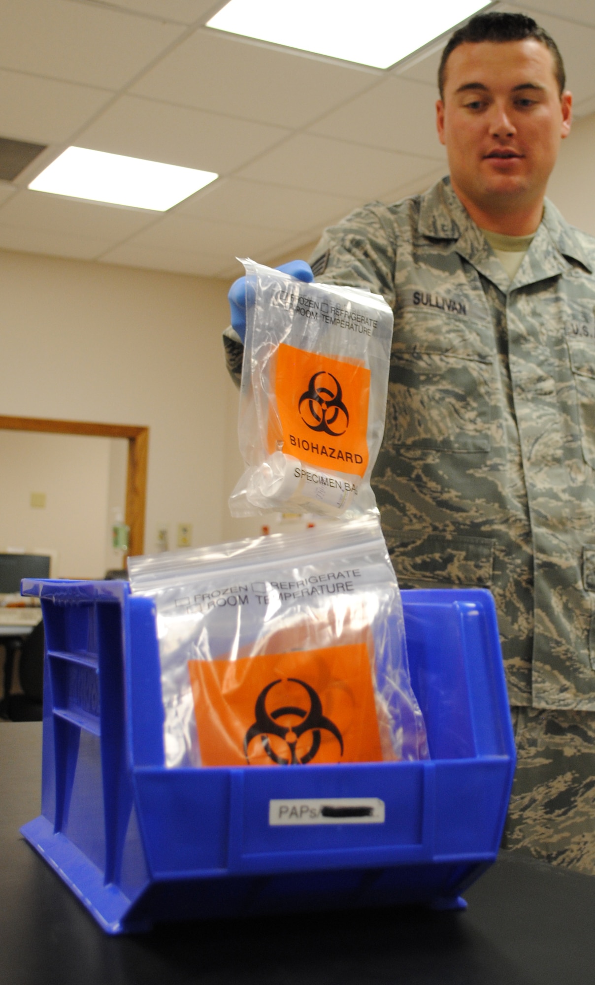 Staff Sgt. Thomas C. Sullivan Jr., 319th Medical Support Squadron laboratory technician, carefully places two more medical samples into a bin for shipment May 22, 2013, at the medical laboratory on Grand Forks Air Force Base, N.D. The base medical laboratory complies with federal regulations and laws for medical sample handling by using plastic bags with warning labels such as the biohazard symbol. (U.S. Air Force photo/Staff Sgt. Luis Loza Gutierrez)