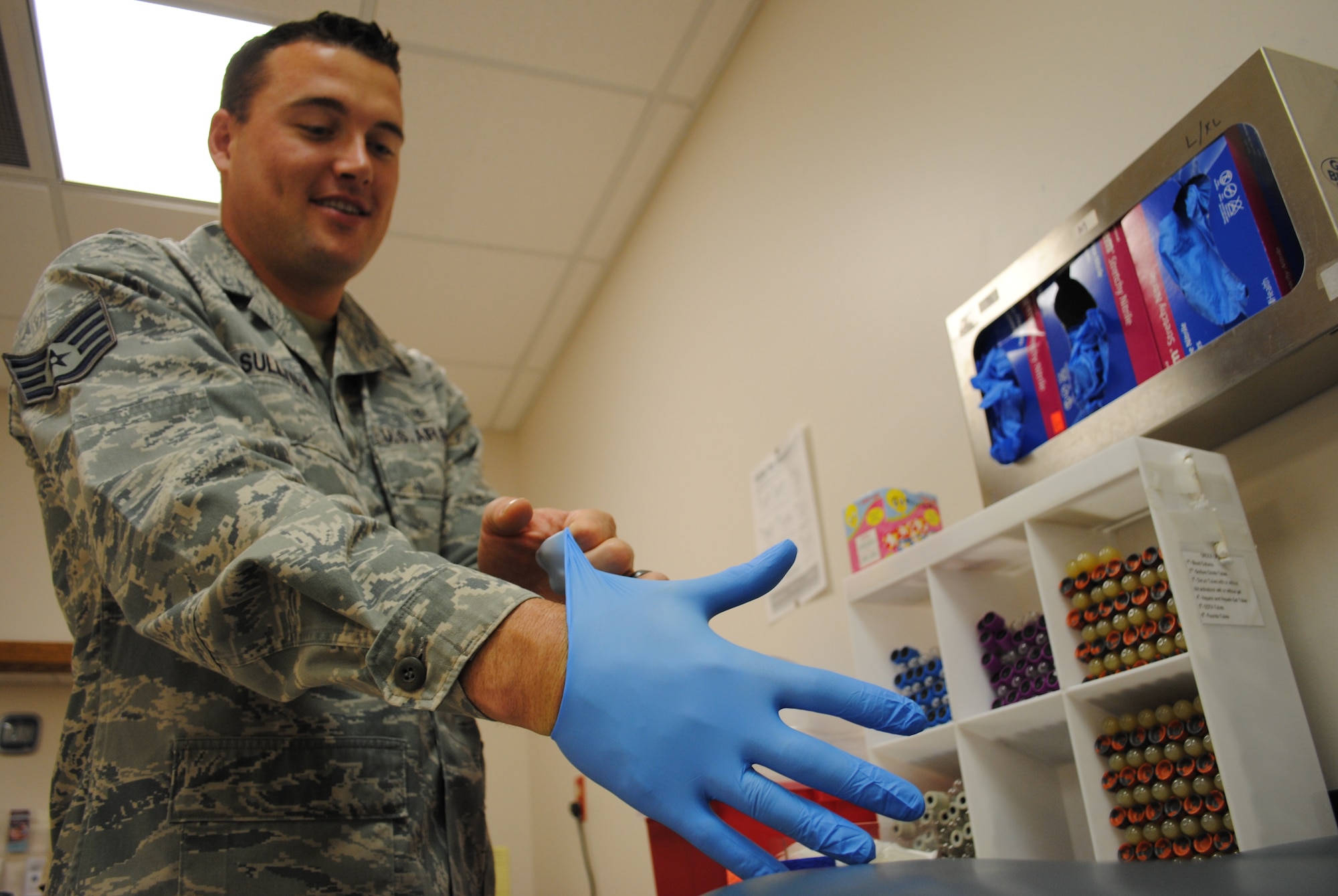 Staff Sgt. Thomas C. Sullivan Jr., 319th Medical Support Squadron laboratory technician, prepares to take a blood sample from a patient May 22, 2013, at the medical laboratory on Grand Forks Air Force Base, N.D. Rubber gloves are used by lab technicians in order to safely handle medical patient samples, such as urine or blood. (U.S. Air Force photo/Staff Sgt. Luis Loza Gutierrez)
