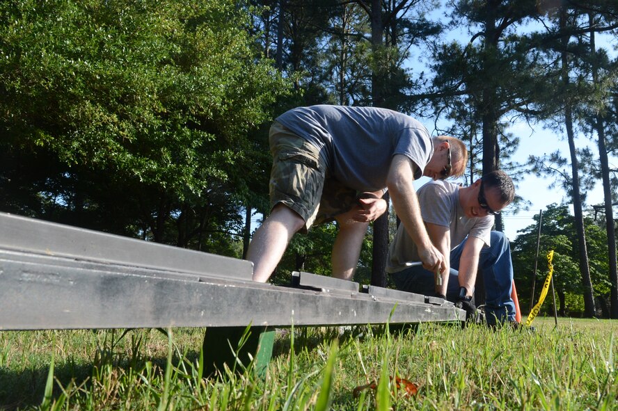 U.S. Air Force Staff Sgt. Michael Garza, 20th Logistics Readiness Squadron travel management office NCO, and Master Sgt. Seth Lash, 9th Air Force antiterrorism course protection manager, build the traveling Vietnam War memorial at Swan Lake, Sumter, S.C.  Volunteers watched the wall for 24-hour shifts to commemorate the sacrifice made by the service members whose names are on the wall.  (U.S. Air Force photo by Airman 1st Class Nicole Sikorski/Released) 