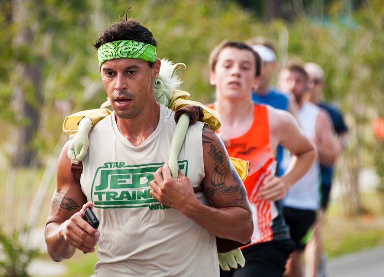 Dennis Ruiz Jr., continues his jedi training with his master in tow on his back at the 28th annual Gate-to-Gate Run May 27 at Eglin Air Force Base, Fla. More than 1,500 people participated in the Memorial Day race.  Many of the runners paid their respects by dropping off flowers in front of the All Wars Memorial as they raced by.  (U.S. Air Force photo/Samuel King Jr.)
