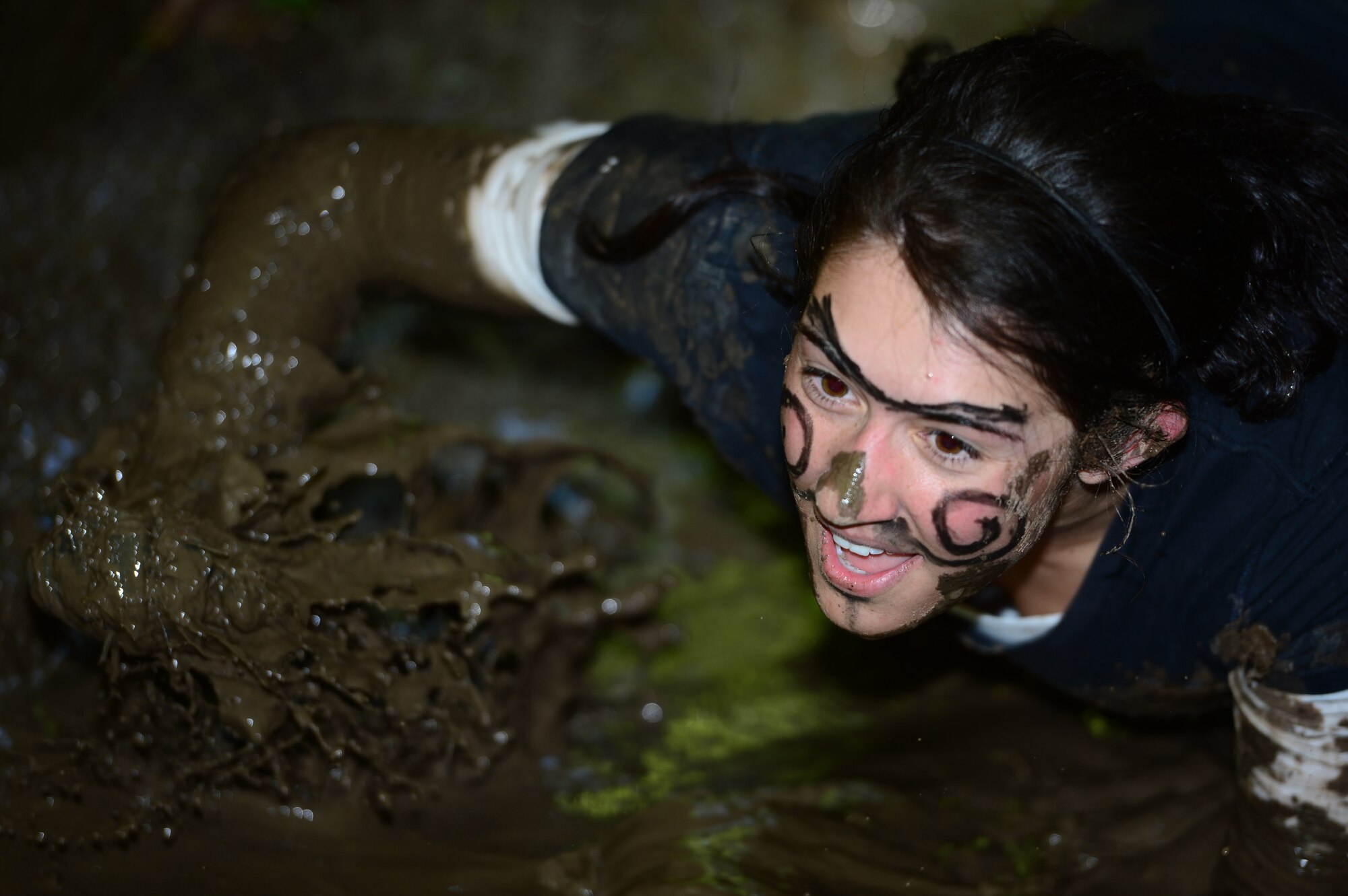 SPANGDAHLEM AIR BASE, Germany - U.S. Air Force Senior Airman Kristen Deming, 52nd Comptroller Squadron customer service technician from Jackson, Tenn., claws her way through the mud during the Tier II Saber sprint May 24, 2013. Members were encouraged to form teams with each having unique themes and names. (U.S. Air Force photo by Staff Sgt. Christopher Ruano/Released)
