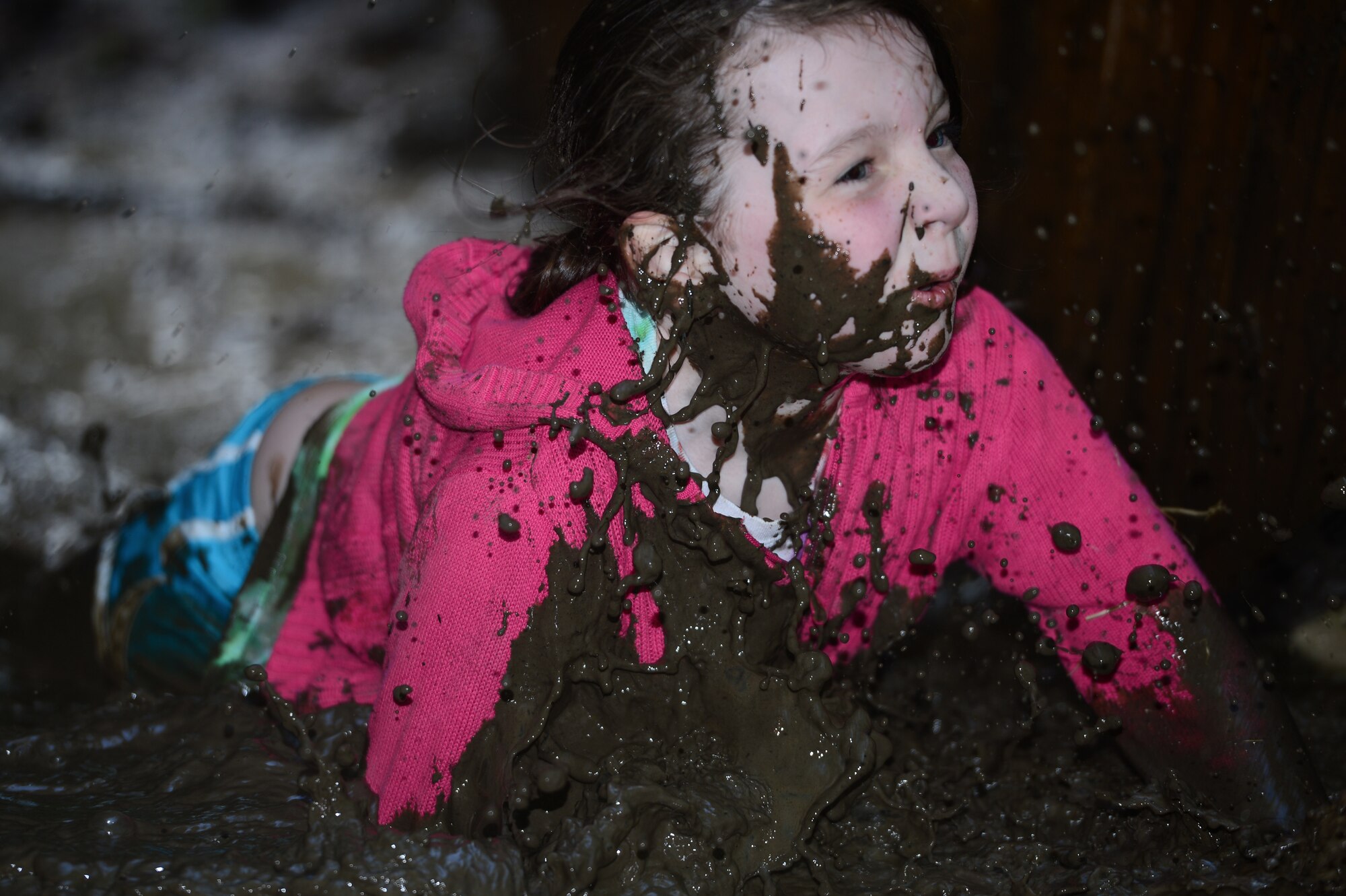 SPANGDAHLEM AIR BASE, Germany - Jaden Pelland, daughter of U.S. Air Force Senior Airman Jordan Williams, 606th Air Control Squadron, client system technician from Missoula, Mont., falls into a mud puddle during an obstacle during the Tier II Saber Sprint May 24, 2013. Pelland was the youngest and smallest participant in the Tier II Saber Sprint and was recognized during the closing ceremony. (U.S. Air Force photo by Staff Sgt. Christopher Ruano/Released)