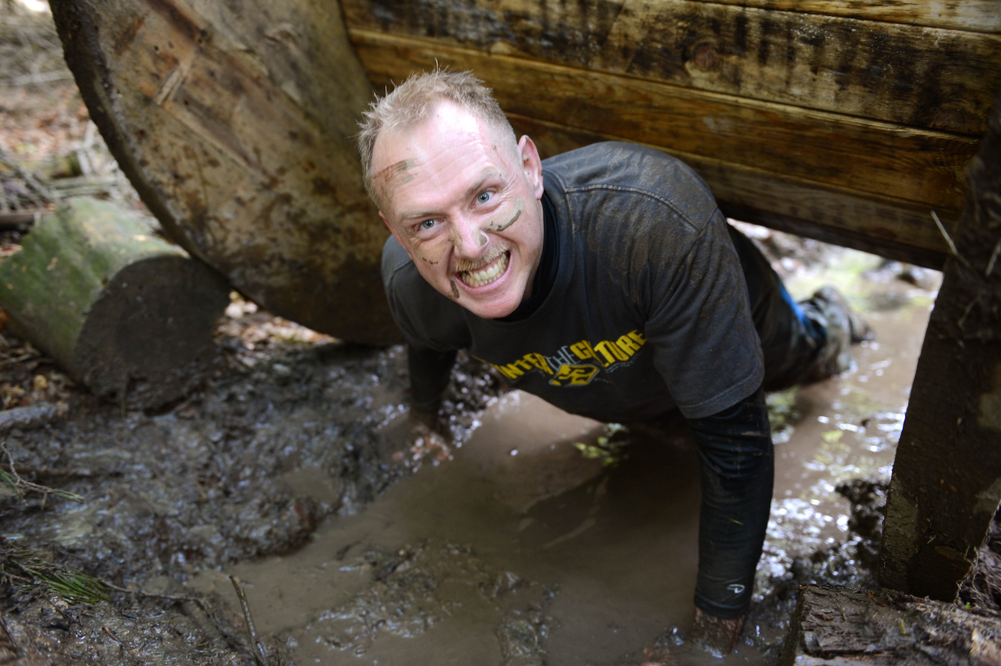 SPANGDAHLEM AIR BASE, Germany - U.S. Air Force Senior Master Sgt. Rick Allenbaugh, 52nd Component Maintenance Squadron lead pro supervisor from Punxsutawney, Pa., crawls through an obstacle during the Tier II Saber Sprint May 24, 2013. Tier II Saber Sprint, a 5K run similar to the Tough Mudder, raised $2,710 for the Wounded Warrior program, which helps provide aid to injured service members. (U.S. Air Force photo by Airman 1st Class Kyle Gese/Released)