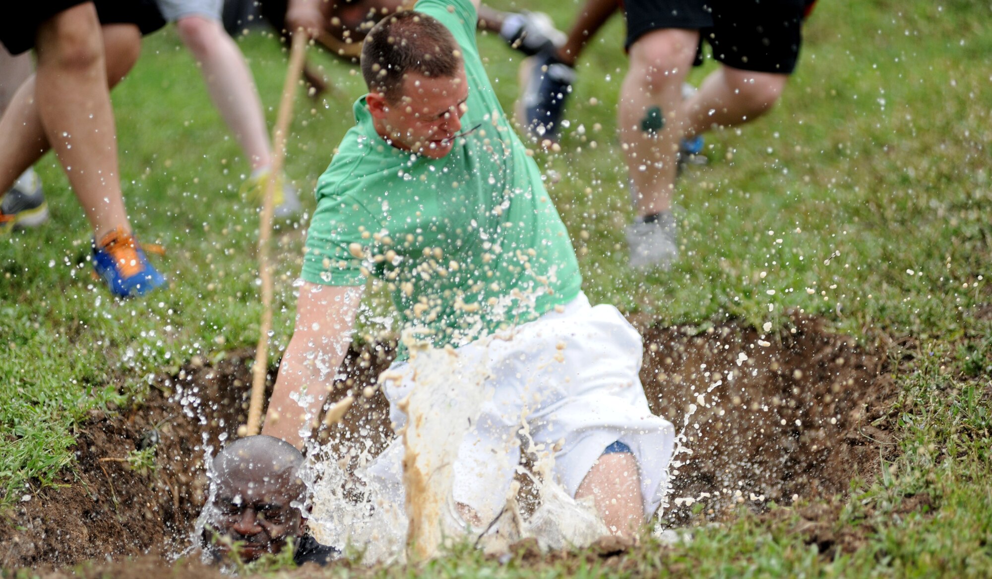 Participants fall into the mud pit during the 39th Air Base Wing Sports Day tug-of-war event May 24, 2013, at Incirlik Air Base, Turkey. Sports day was an event that brought Airmen together through sports and recreation. Airmen from several squadrons competed in friendly games of volleyball, softball, basketball, kickball, dodgeball and tug-of-war. (U.S. Air Force photo by Senior Airman Jarvie Z. Wallace/Released) 