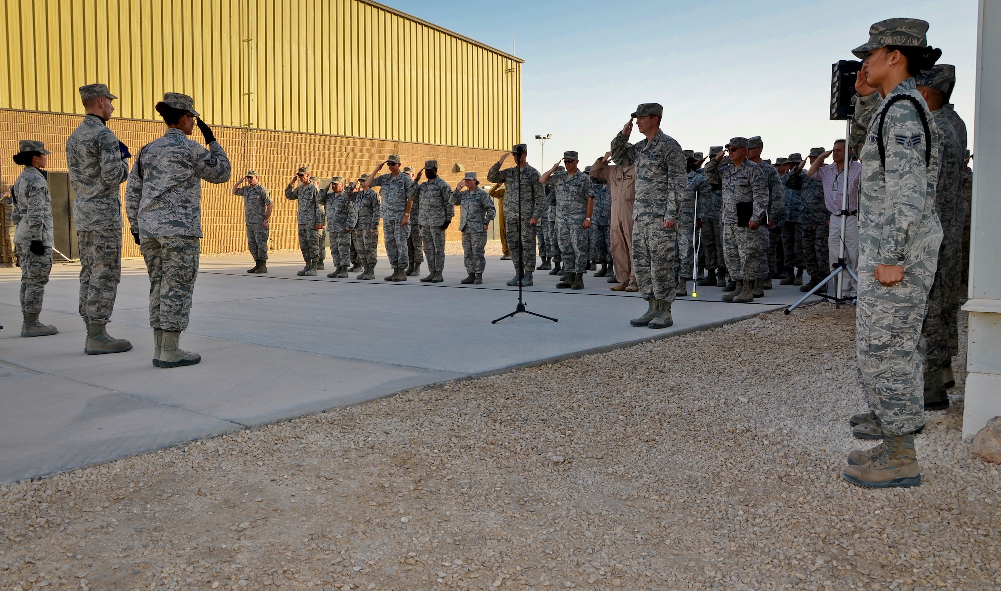 U.S. and coalition forces deployed to the 379th Air Expeditionary Wing salute the American flag during a Memorial Day retreat ceremony, May 27, 2013, at Memorial Plaza in Southwest Asia. Military retreat ceremonies serve a twofold purpose: to signal the end of the official duty day and to pay respect to the U.S. flag. (U.S. Air Force photo/Senior Airman Benjamin Stratton)