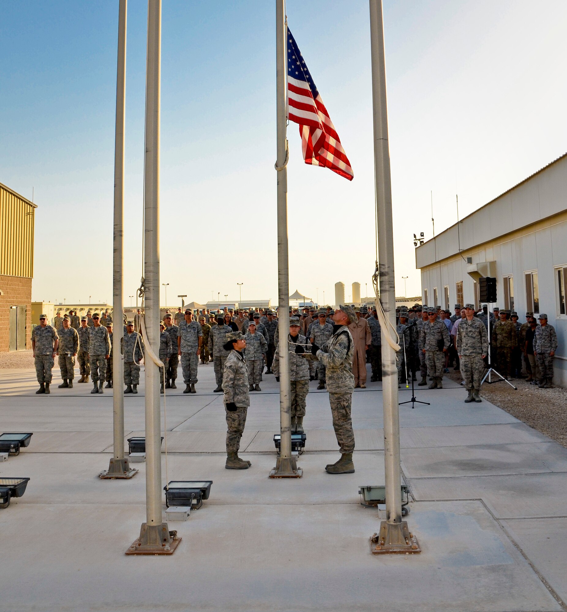 Honor guard members deployed to the 379th Air Expeditionary Wing attend to the colors during a Memorial Day retreat ceremony, May 27, 2013, at Memorial Plaza in Southwest Asia. Military retreat ceremonies serve a twofold purpose: to signal the end of the official duty day and to pay respect to the U.S. flag. (U.S. Air Force photo/Senior Airman Benjamin Stratton)