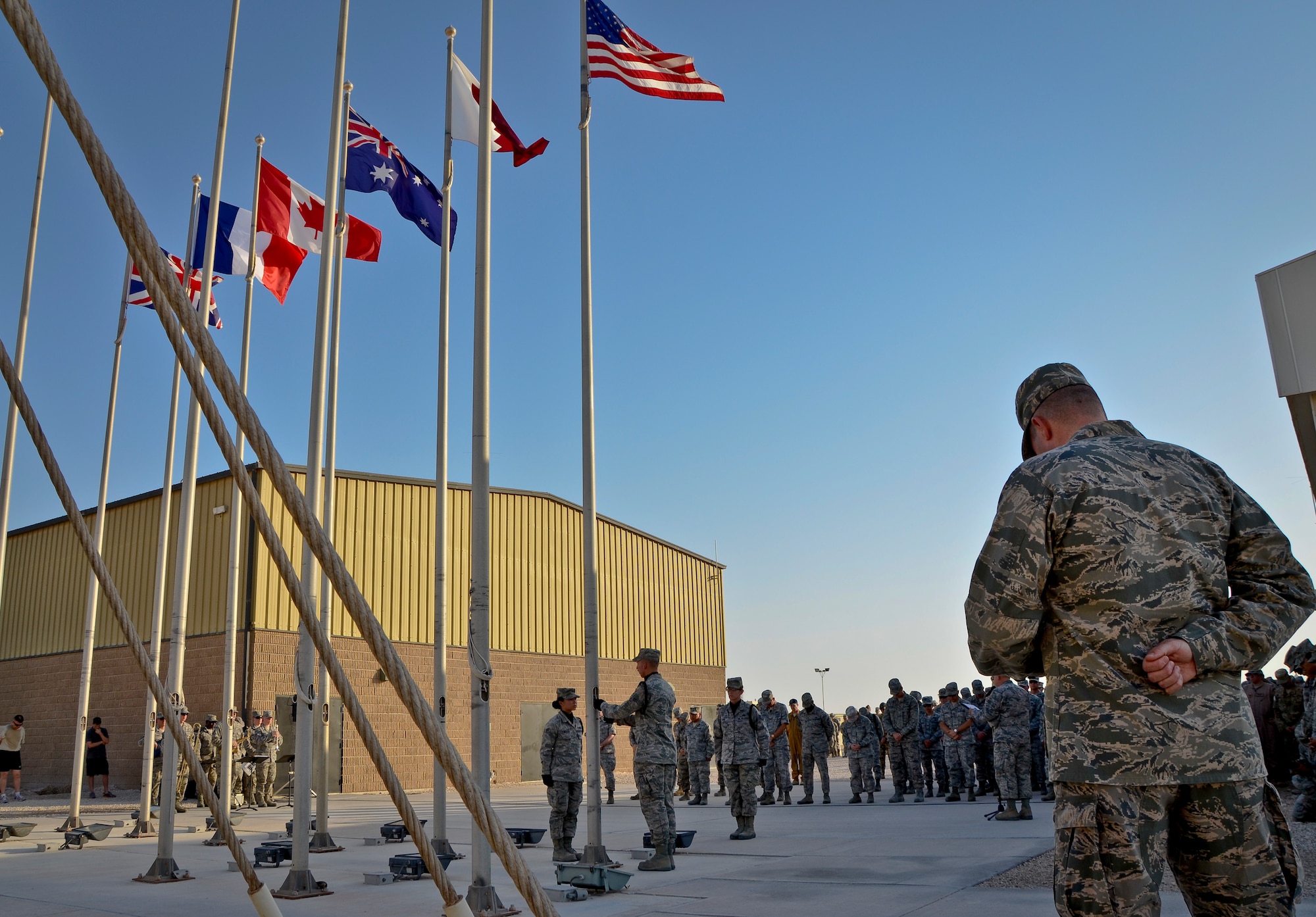 Honor guard members deployed to the 379th Air Expeditionary Wing attend to the colors as Chaplain (Col.) Bruce Glover gives the invocation during a Memorial Day retreat ceremony, May 27, 2013, at Memorial Plaza in Southwest Asia. Glover is the 379th AEW wing chaplain. (U.S. Air Force photo/Senior Airman Benjamin Stratton)