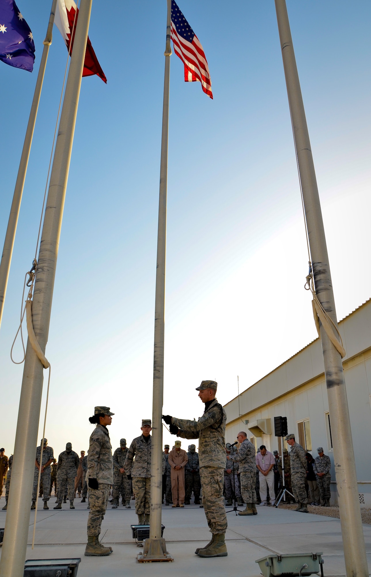 Honor guard members deployed to the 379th Air Expeditionary Wing attend to the colors as Chaplain (Col.) Bruce Glover gives the invocation during a Memorial Day retreat ceremony, May 27, 2013, at Memorial Plaza in Southwest Asia. Glover is the 379th AEW wing chaplain. (U.S. Air Force photo/Senior Airman Benjamin Stratton)