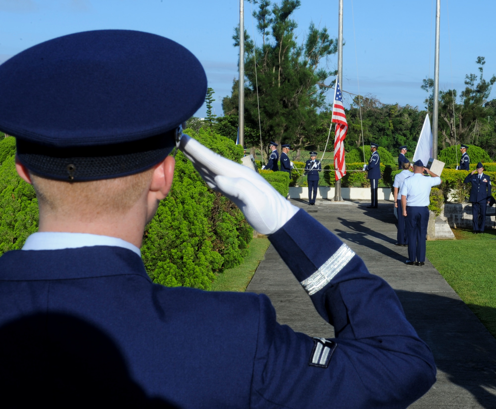 U.S. Air Force Airman 1st Class Kevin Greer, Kadena Honor Guard member, salutes as the American Flag rises during the Memorial Day ceremony on Kadena Air Base, Japan, May 27, 2013. It is a tradition on Memorial Day for the U.S. Flag to be raised to the top of the staff and then lowered to the half-staff position, in remembrance of more than one million men and women who gave their lives in service of their country. (U.S. Air Force photo by Airman 1st Class Justin Veazie/Released)