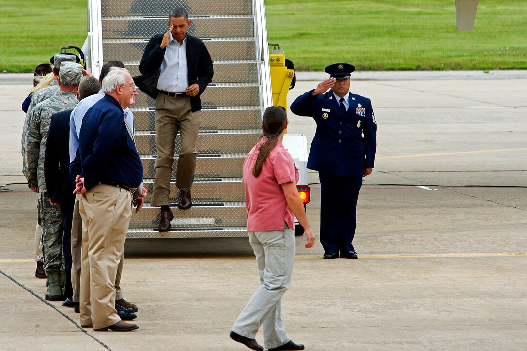 President Barack Obama salutes as he steps off Air Force One on Tinker