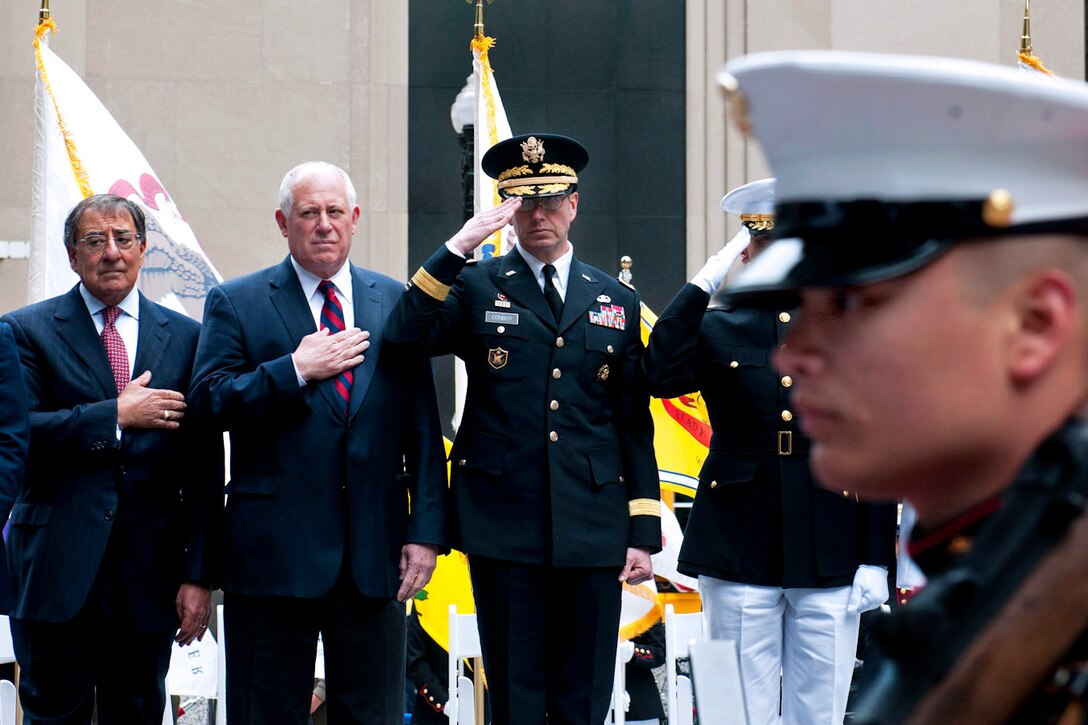 Former Defense Secretary Leon E. Panetta, left, Illinois Gov. Pat Quinn, center, and Army Maj. Gen. David Conboy, right, commanding general of the Army Reserve 416th Theater Engineer Command, render honors during a wreath-laying ceremony at the Eternal Flame at Daley Plaza in Chicago, May 25, 2013.