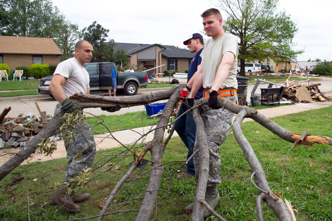 Air Force Technical Sgt. Omar Torres, Senior Airman Robert Rovnak and Staff Sgt. Theodore Muenster help clean up a home in Moore, Okla., May 24, 2013, after devastating tornado damage. Torres, Rovnak and Muenster are assigned to the 552nd Maintenance Squadron, Tinker Air Force Base, Okla.