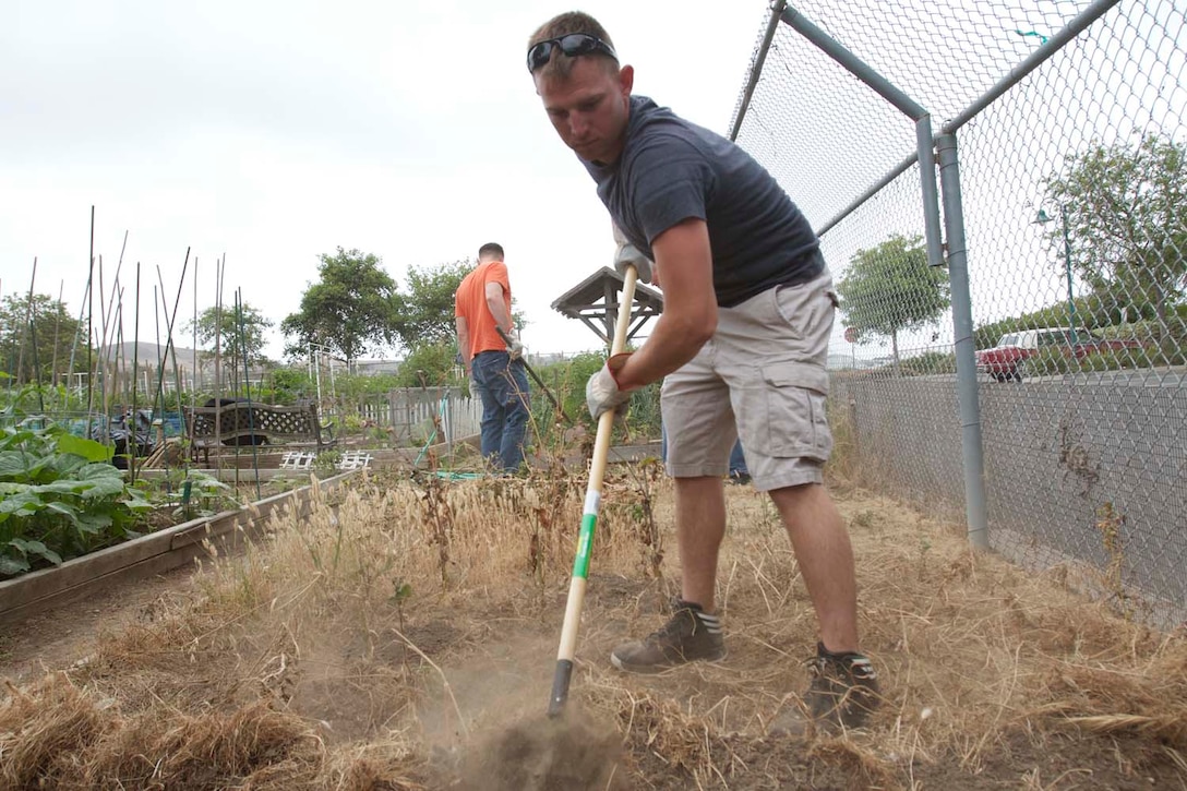 Sergeant Steven Soper, an artilleryman serving with 1st Battalion, 11th Marine Regiment, rakes away debris from a garden here, May 23, 2013. Marines from the battalion participated in helping the citizens of San Juan Capistrano clean up their community and beautify their community center. The event was designed to strengthen relations between the regiment and the city of San Juan Capistrano. Soper is a native of El Dorado, Kan.
