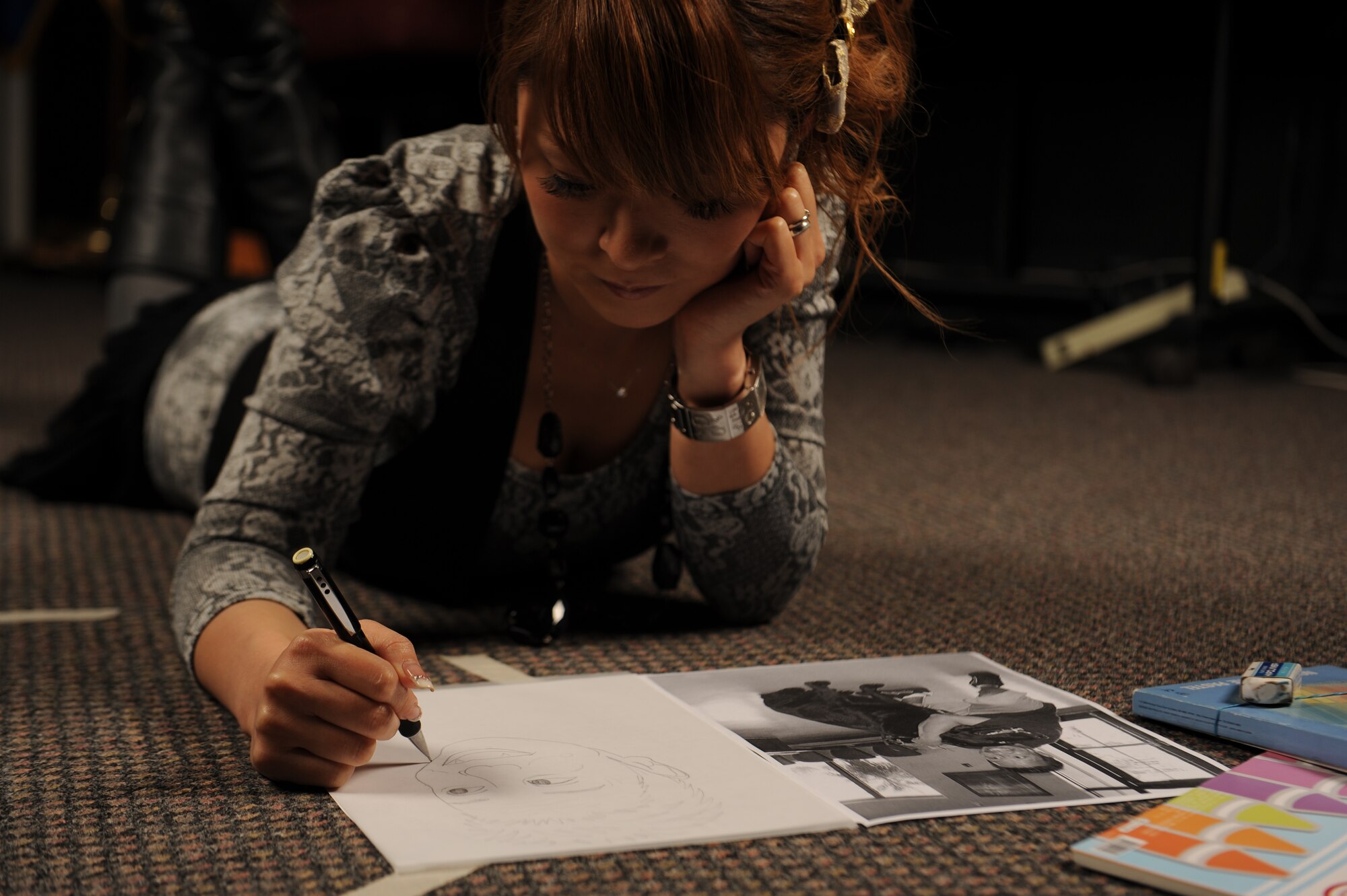 Shoko Higa, 18th Security Forces Squadron reports and analysis administrator specialist, draws a picture of a security forces civilian guard for his birthday on Kadena Air Base, Japan, May 23, 2013. Before becoming a civilian guard with the security forces squadron, Higa was a contractor with the 733rd Air Mobility Squadron. (U.S. Air Force photo by Airman 1st Class Malia Jenkins/Released)