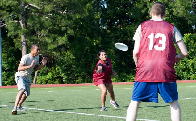 Jackie Ilhan, middle, a member of the 1st Special Operations Wing team, passes the frisbee to a teammate during the first game of the Ultimate Frisbee season on Hurlburt Field, Fla., May 21, 2013. (U.S. Air Force photo by Airman 1st Class Jeffrey Parkinson)