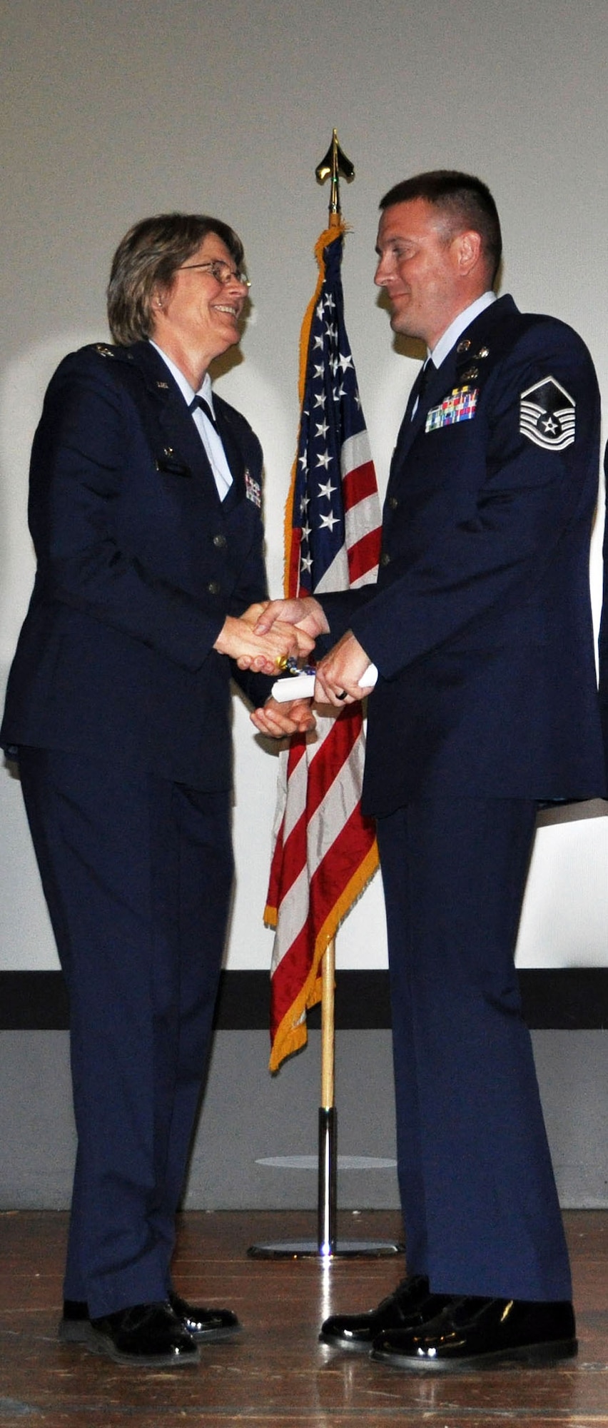 TRAVIS AIR FORCE BASE, Calif. -- Master Sgt. Gary Charles, 349th Air Mobility Wing Financial Management, is presented his CCAF degree Apr. 30, by Col. Nancy Brooks, 349th MSG commander. Thirty-eight Airmen assigned to the wing were awarded degrees in a combined ceremony with Travis's 60th AMW and the 621st Contingency Response Wing West. (U.S. Air Force photo/Tech. Sgt. Moses Gines) 