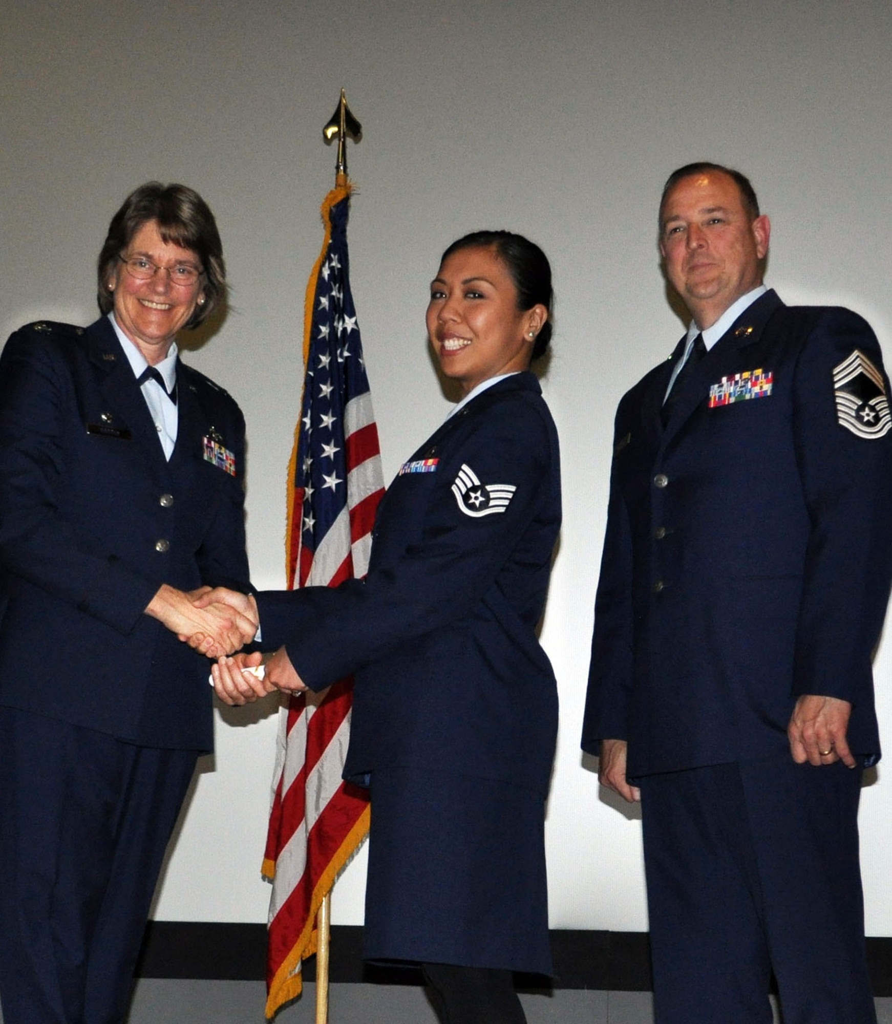 TRAVIS AIR FORCE BASE, Calif. -- Col. Nancy Brooks, 349th MSG commander, congratulates Staff Sgt. Janet Montemayor as she receives her CCAF degree Apr. 30, 2013, as Chief Master Sgt. Mark Kloeppel looks on. Montemayor is a reservist assigned to the 349th Aeromedical Staging Squadron. (U.S. Air Force photo/Tech. Sgt. Moses Gines). 