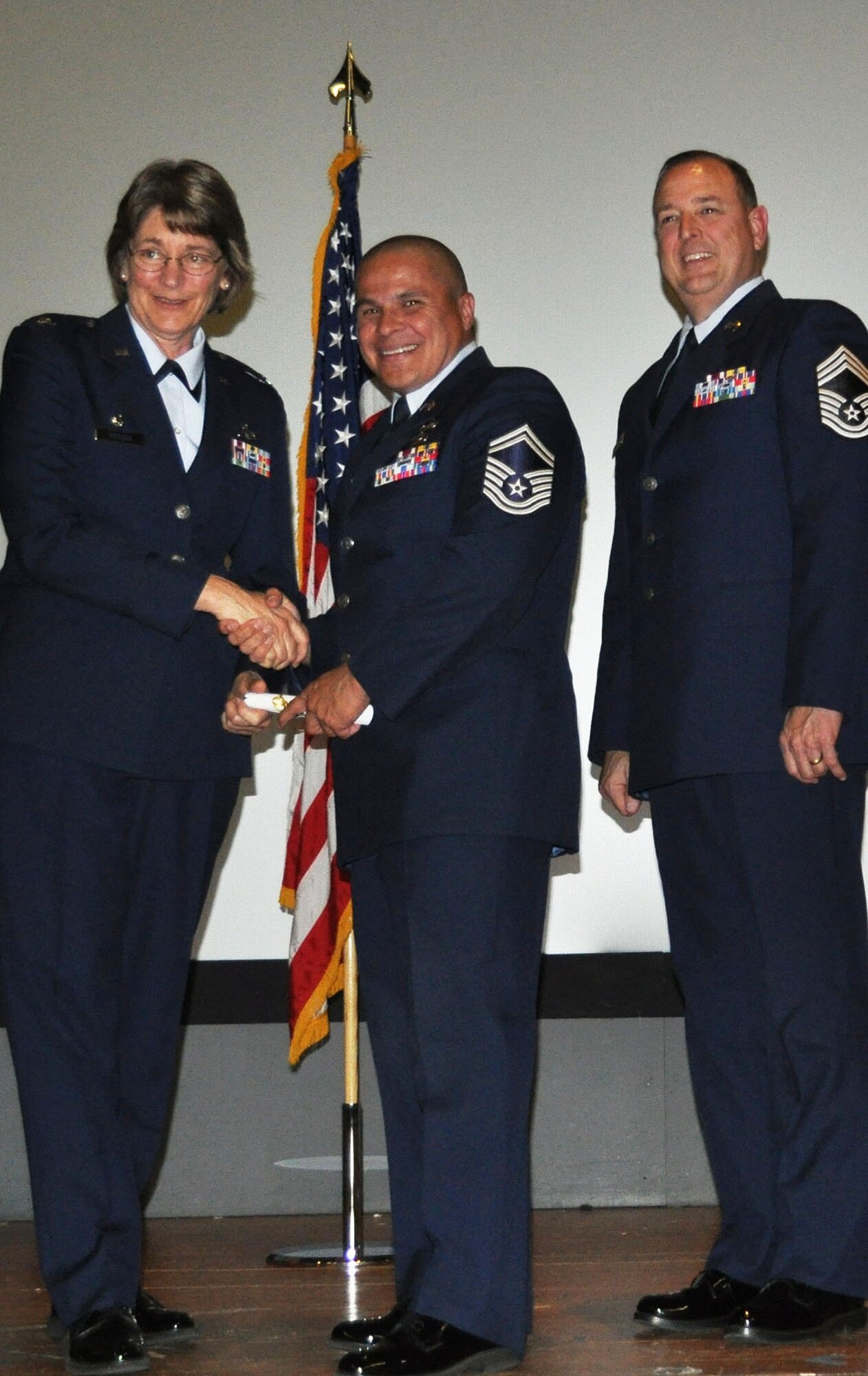 TRAVIS AIR FORCE BASE, Calif. -- Senior Master Sgt. Loren Nickell, 349th Logistics Readiness Squadron, receives his CCAF degree from 349th MSG Commander, Col. Nancy Brooks, Apr. 30, 2013. Chief Master Sgt. Mark Kloeppel waits to congratulate the new graduate. Thirty-eight Airmen assigned to the Travis AFB Reserve wing received degrees. (U.S. Air Force photo/Tech. Sgt. Moses Gines)