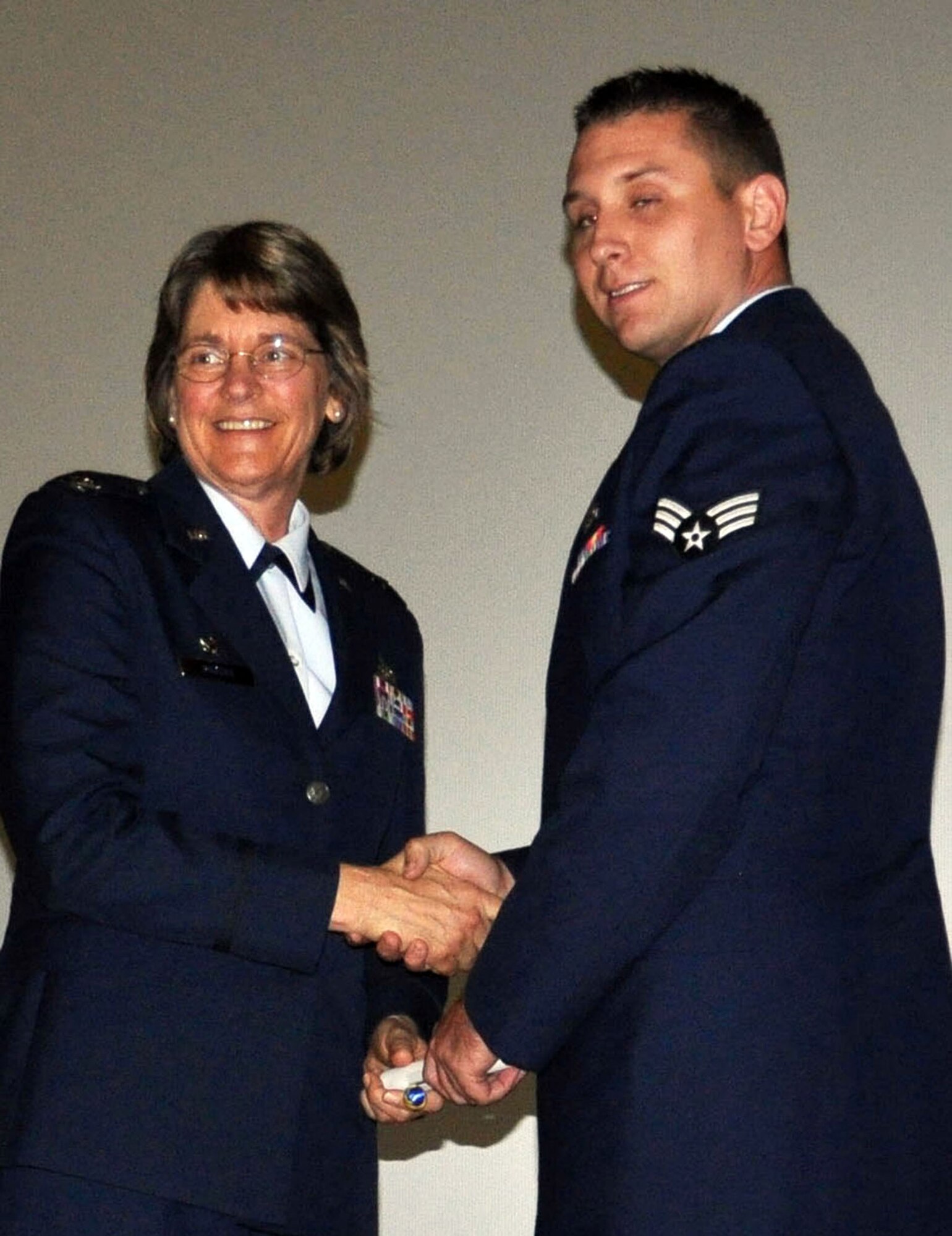 TRAVIS AIR FORCE BASE, Calif. -- Senior Airman Calvin Penwell receives his CCAF degree Apr. 30, 2013, from Col. Nancy Brooks, 349th MSG commander. Penwell was one of 38 Airmen assigned to the Reserve's 349th AMW, Travis AFB, Calif., to receive his degree in an afternoon ceremony. He is assigned to the 945th Aircraft Maintenance Squadron. (U.S. Air Force photo/Tech. Sgt. Moses Gines)
