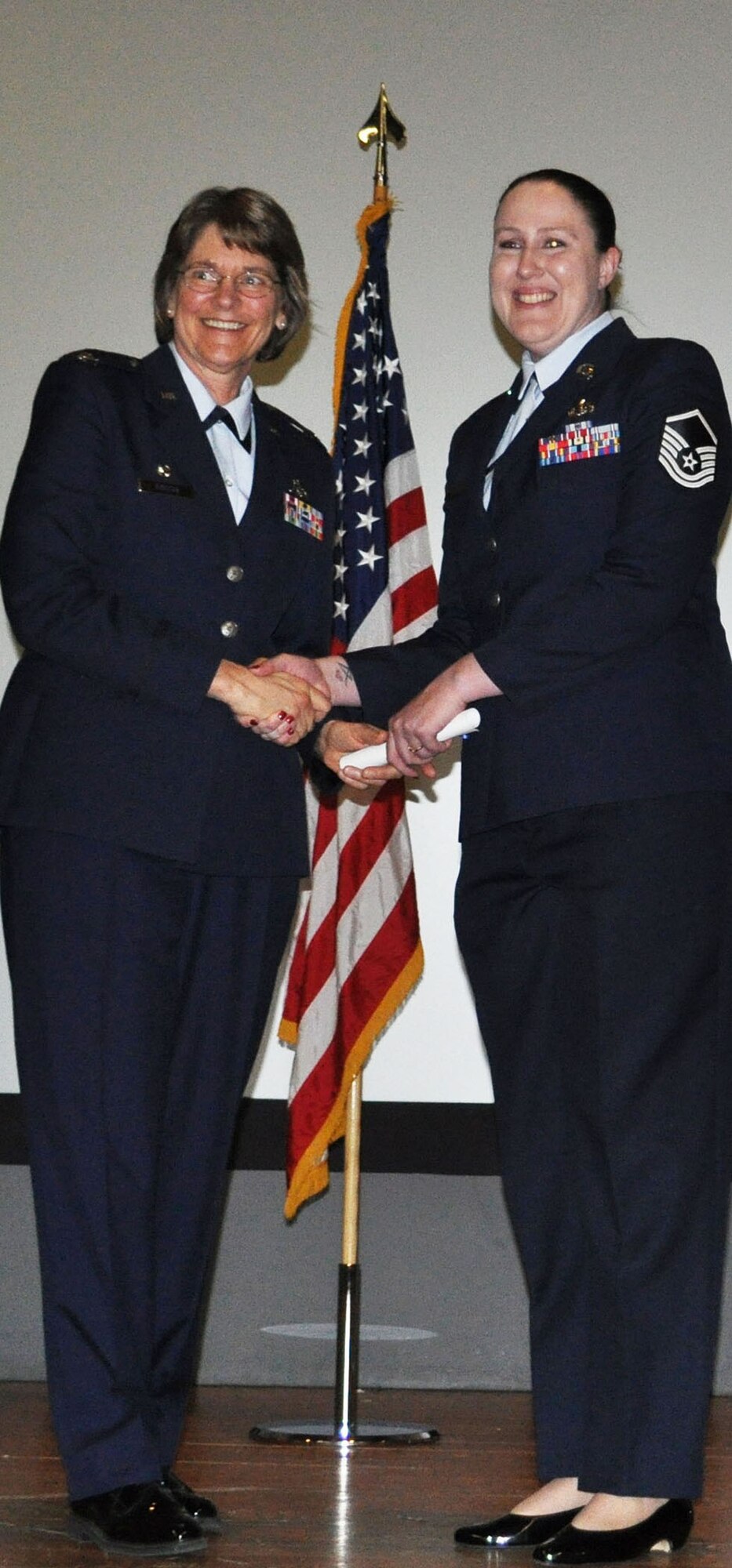 TRAVIS AIR FORCE BASE, Calif. -- A smiling Master Sgt. Veronica Rooks, 349th Memorial Affairs Squadron, receives her CCAF degree from Col. Nancy Brooks, 349th MSG commander, Apr. 30, 2013. Rooks was one of 38 reservists assigned to Travis AFB to receive her degree. (U.S. Air Force photo/Tech. Sgt. Moses Gines)