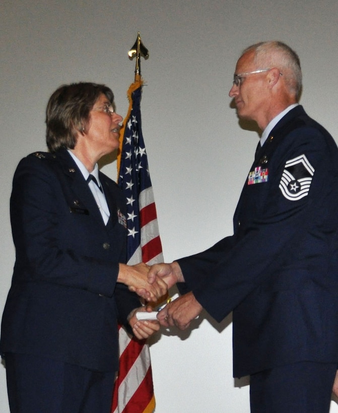 TRAVIS AIR FORCE BASE, Calif. -- Col. Nancy Brooks, 349th Mission Support Group Commander, presents Senior Master Sgt. Dale Smelser with his CCAF degree Apr. 30, 2013. The Travis Air Force Base reservist is assigned to the 349th Maintenance Group. (U.S. Air Force photo/Tech. Sgt. Moses Gines)